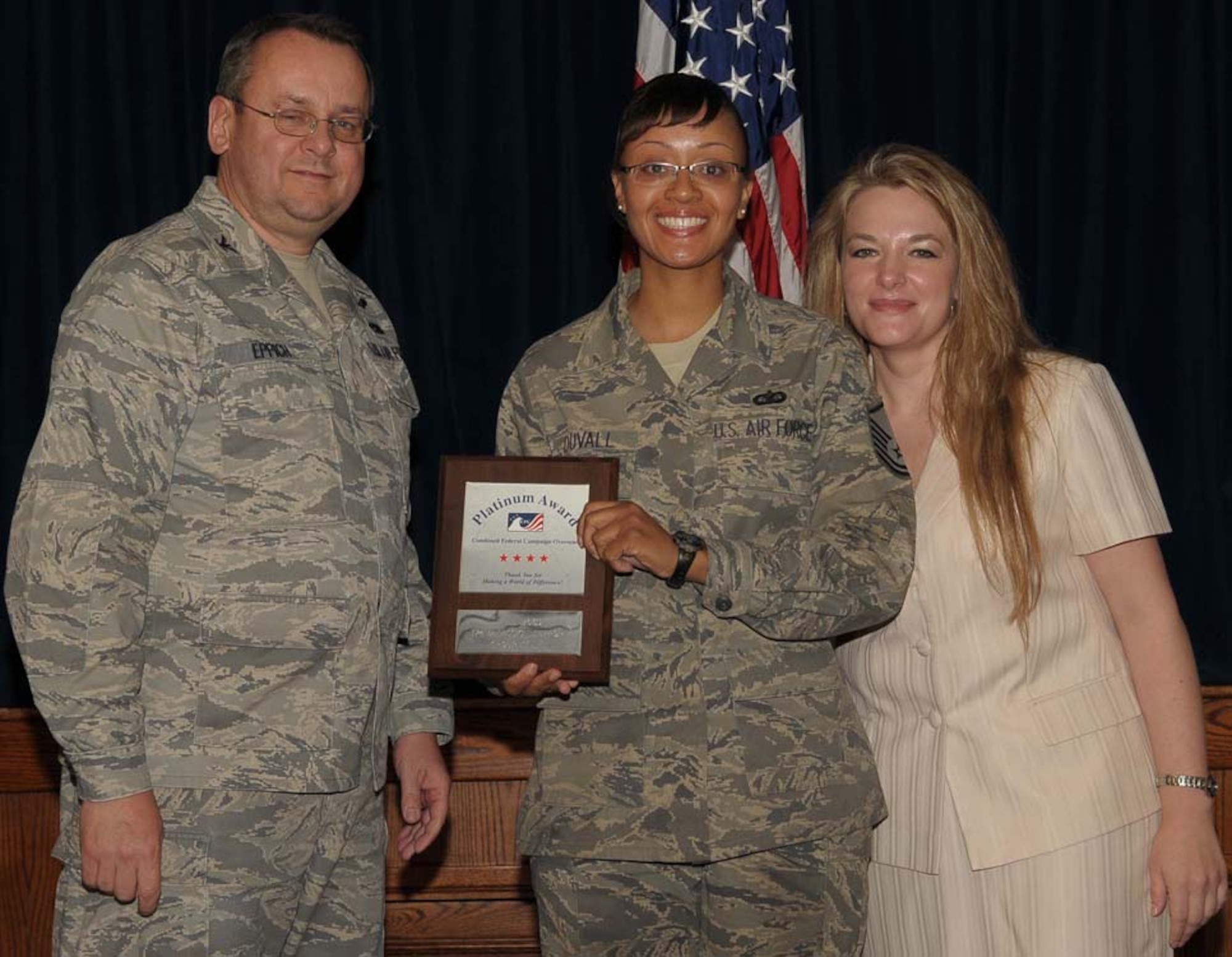 YOKOTA AIR BASE, Japan -- Col. Frank Eppich, 374th Airlift Wing vice commander, and Kitty Malcolm, CFC-O Pacific campaign coordinator, presents the platinum award to MSgt Tracie Duvall, who accepted the award on behalf of the PACAF 374th Mission Support Squadron. The Combined Federal Campaign gives military members and civilian employees the chance to donate money to more than 2,000 charitable organizations. (U.S. Air Force photo/Airman 1st Class Devin Doskey)