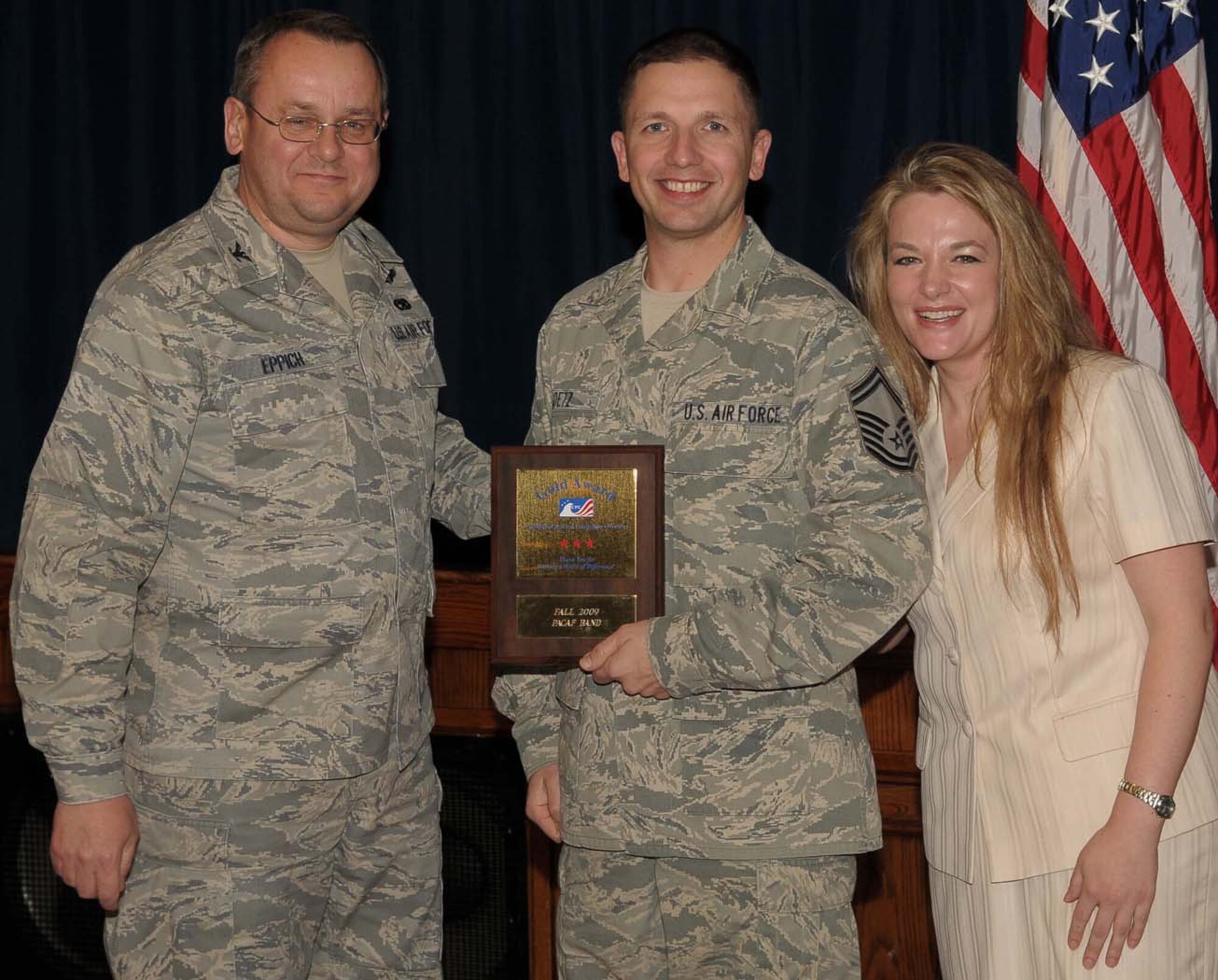 YOKOTA AIR BASE, Japan -- Col. Frank Eppich, 374th Airlift Wing vice commander, and Kitty Malcolm, CFC-O Pacific campaign coordinator, presents the gold award to SMSgt Michael Goetz, who accepted the award on behalf of the PACAF Band. The Combined Federal Campaign gives military members and civilian employees the chance to donate money to more than 2,000 charitable organizations. (U.S. Air Force photo/Airmen 1st Class Devin Doskey)