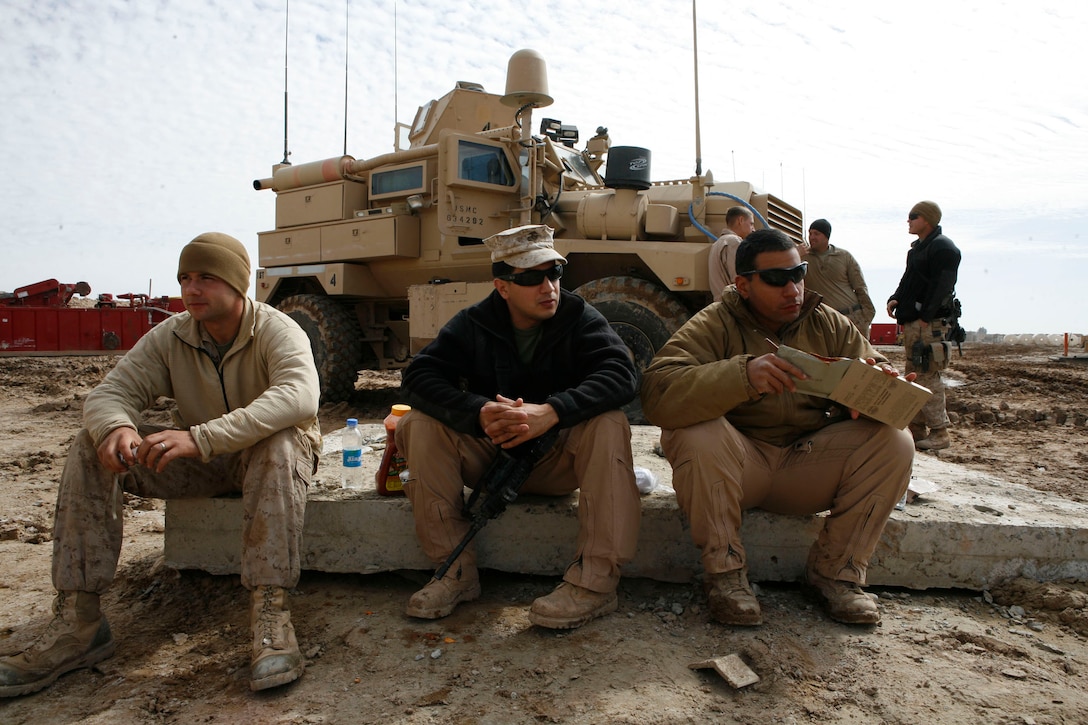 From left to right, U.S. Marine Cpl. Adam C. Thompson, Sgt. Jorge A. Lopez, and Sgt. Sgt. Jonathan J. Sanabria take a moment to eat before departing for their mission to seize intersections of key roads linking the Taliban stronghold in the Marja area with the rest of Helmand province, Marja, Afghanistan, Feb. 9, 2010.