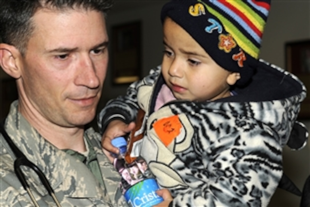 U.S. Air Force Master Sgt. Jan Fink holds a young avalanche survivor who was evacuated to Craig Joint Theater Hospital on Bagram Airfield, Afghanistan, for medical attention, Feb. 9, 2010. Hundreds of Afghans were evacuated from the avalanche-stricken Parwan province. Fink is assigned to the 455th Expeditionary Medical Group.