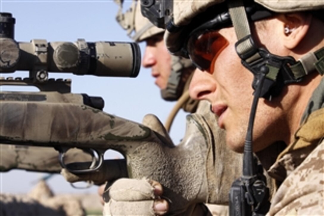 U.S. Marine Lance Cpl. Keith B. Lawson and Lance Cpl. Spence G. Press work together to identify targets as Taliban fighters approach from Marja toward their position at the "Five Points" intersection, Feb. 9, 2010.