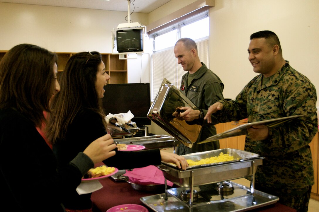 Maj. Mike Jeron, Headquarters and Headquarters Squadron executive officer, and Gunnery Sgt. Rodney Buentello, H&HS squadron gunnery sergeant, helped serve breakfast during a spouse appreciation breakfast at Capodanno Hall Feb. 12. The breakfast was to treat the military spouses on base in gratification of all the hard work and support they provide to service members on a daily basis.