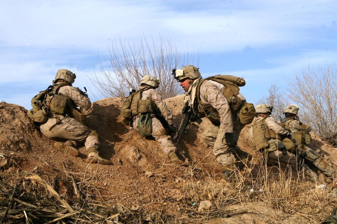 Marines with Bravo Company, 1st Battalion, 6th Marine Regiment, 2nd Marine Division, take cover during the first few hours of fighting in Marjah, Afghanistan, Feb. 13, 2010. Marines and sailors with 1/6 took part in Operation Moshtarak, the second largest offensive in the history of Operation Enduring Freedom, aimed at wresting the city of Marjah from Taliban control.