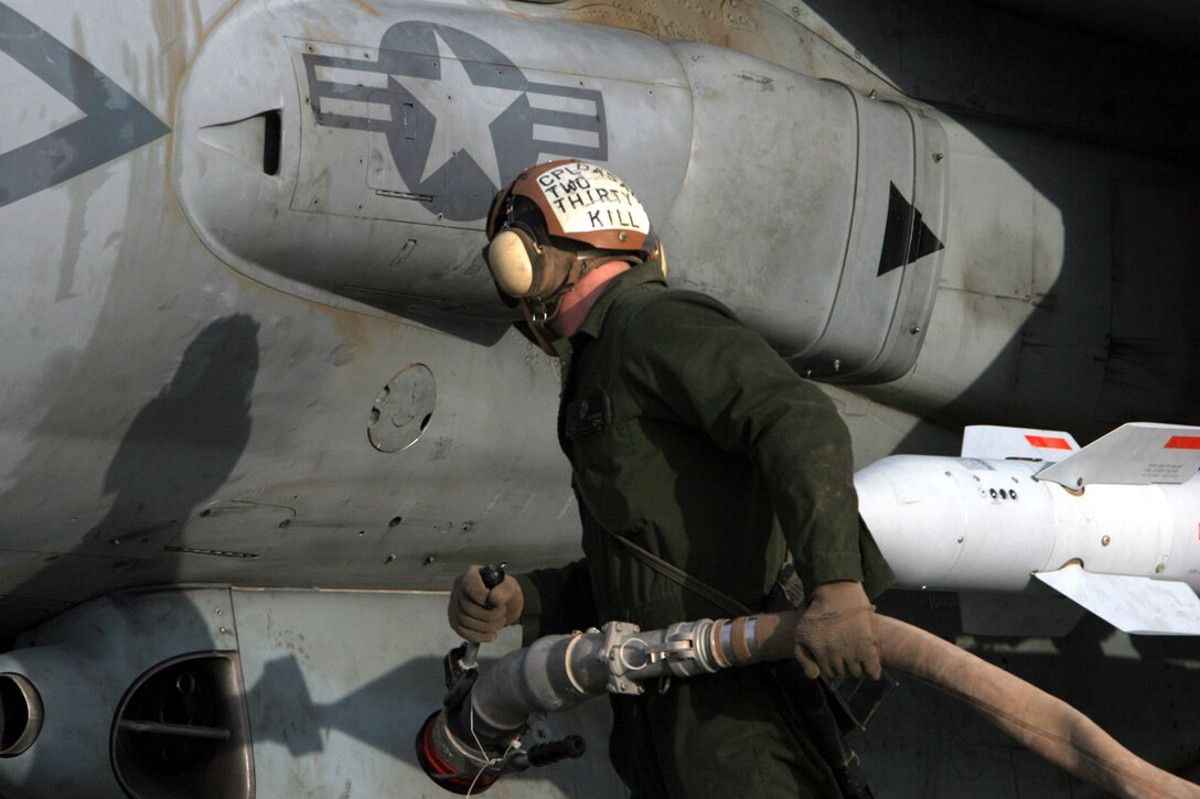Cpl. Nicholas Waters, a plane captain for Marine Attack Squadron 231, Marine Aircraft Group 40, Marine Expeditionary Brigade-Afghanistan, drags a fuel line toward one of the squadron's AV-8B Harriers.  The Harrier landed here, Feb. 13, following an air mission in support of combat operations on Marjah.  (U.S. Marine Corps photo by Lance Cpl. Samuel Nasso)