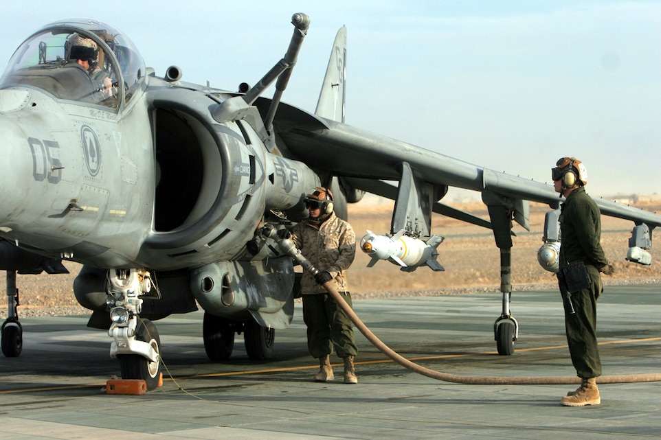 Sgt. Caleb Bailey, left, an AV-8B Harrier mechanic with Marine Attack Squadron 231, Marine Aircraft Group 40, Marine Expeditionary Brigade-Afghanistan, refuels one of the squadrons aircraft while Cpl. Nicholas Waters, a plane captain with the squadron, assists by giving the pilot any needed instructions and signaling the bulk fuel Marines when it is time to turn off the fuel pump. The squadron tested the refuel capabilities here just days before starting combat operations in support of troops inserted into Marjah. (U.S. Marine Corps photo by Lance Cpl. Samuel Nasso)