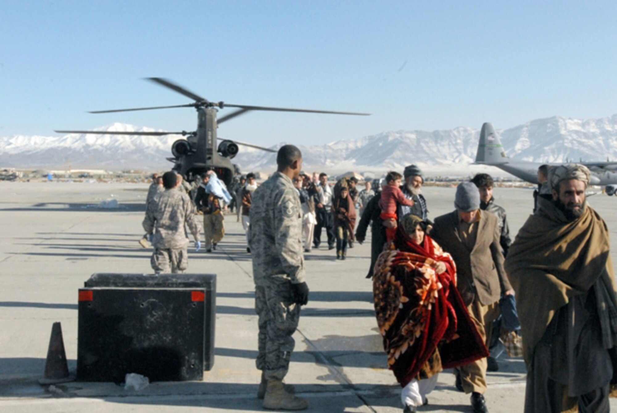 Avalanche evacuees exit a CH-47 Chinook helicopter at Bagram Airfield's flightline in Afghanistan, Feb. 9. Service members with Task Forces Cyclone, Falcon, Med. and the 455th Air Expeditionary Wing, medically assisted hundreds of people rescued from the avalanche stricken area while 380th Air Expeditionary Wing Airmen take control of the sky providing safety, security and air management during the joint-force humanitarian effort. (U.S. Army Photo/Spc. William Henry)