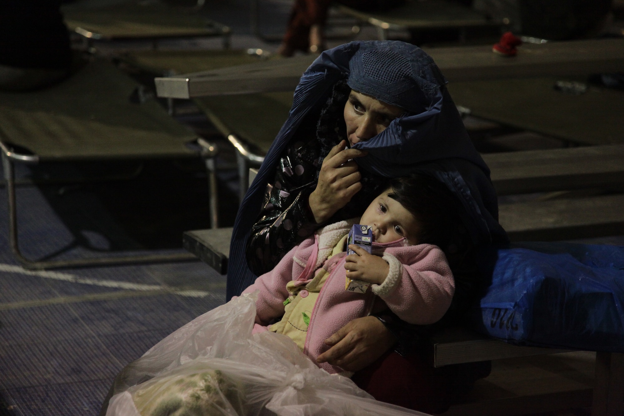 Mother and daughter rescuees from an avalanche in the Salang Pass await processing at a building on Bagram Airfield, Afghanistan. The avalanche occurred in the Parwan Provice Feb. 9. A combined effort of Afghan Army, International Security Assistance Forces and U.S. forces, made the rescues possible. (Photo/U.S. Army Sgt. Derec Pierson)