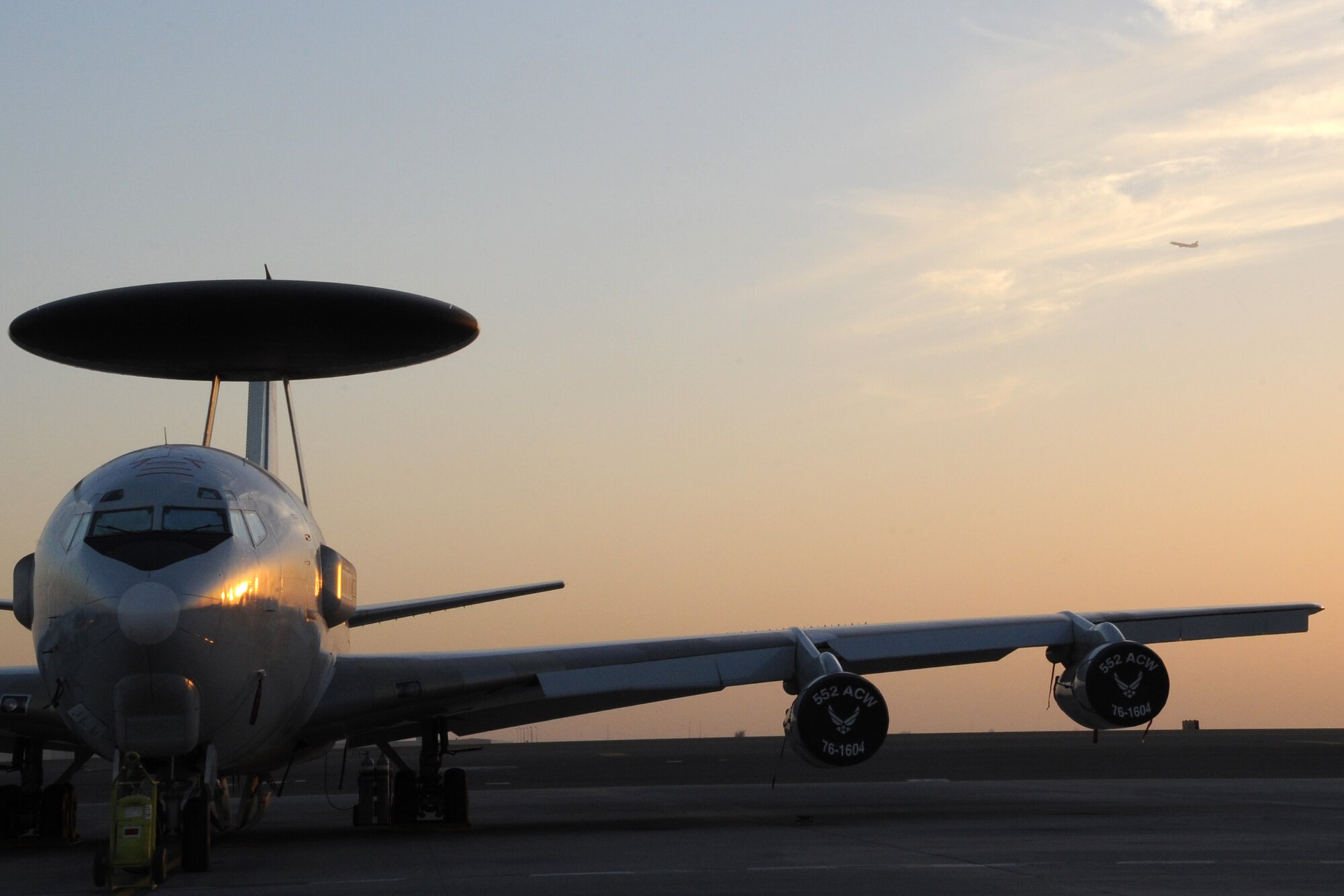 An E-3 Sentry Airborne Warning and Control System aircraft sits on the runway as a KC-10 Extender takes off at an undisclosed location in Southwest Asia on Feb.12, 2010.The E-3 Sentry is a modified Boeing 707/320 commercial airframe with a rotating radar dome that provides situational awareness of friendly, neutral and hostile activity, command and control of an area of responsibility, battle management of theater forces, all-altitude and all-weather surveillance of the battle space, and early warning of enemy actions during joint, allied, and coalition operations. The KC-10's primary mission is aerial refueling but can combine the tasks of a tanker and cargo aircraft by refueling fighters and simultaneously carry the fighter support personnel and equipment. (U.S. Air Force photo/Senior Airman Jenifer H. Calhoun/Released)
