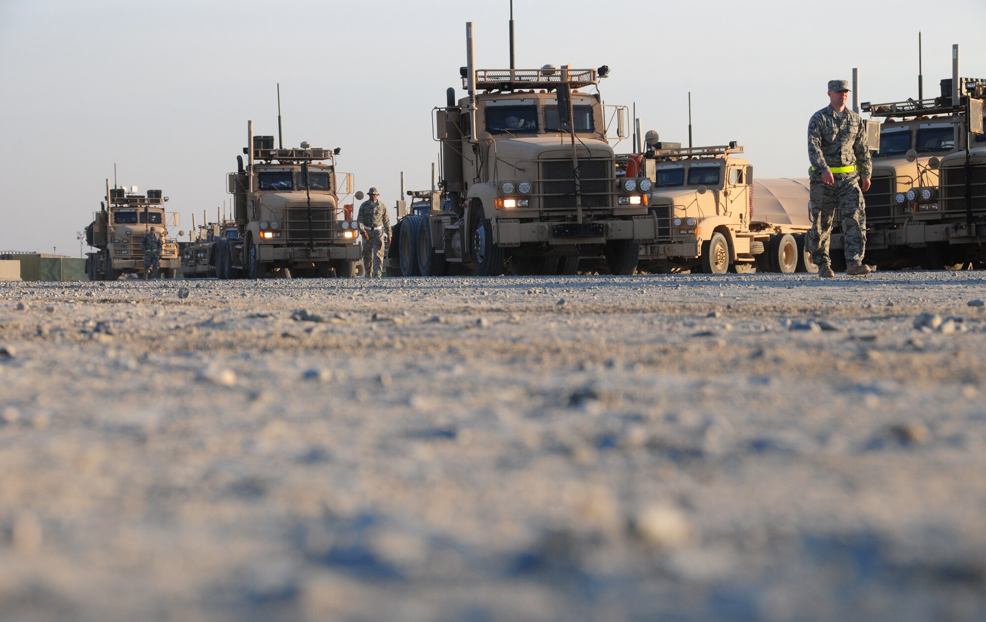 U.S. Air Force Staff Sgt. Chris Poole, right, 70th Medium Truck Detachment alternate convoy commander, ground guides a vehicle within a convoy out of the compound on a military installation in Southwest Asia during a mail mission Jan. 27, 2010. The 70th MTD took on the mail mission Dec. 28, 2009, when a Department of Defense contract with a transport company was halted. (U.S. Air Force photo by Staff Sgt. Lakisha A. Croley/Released)