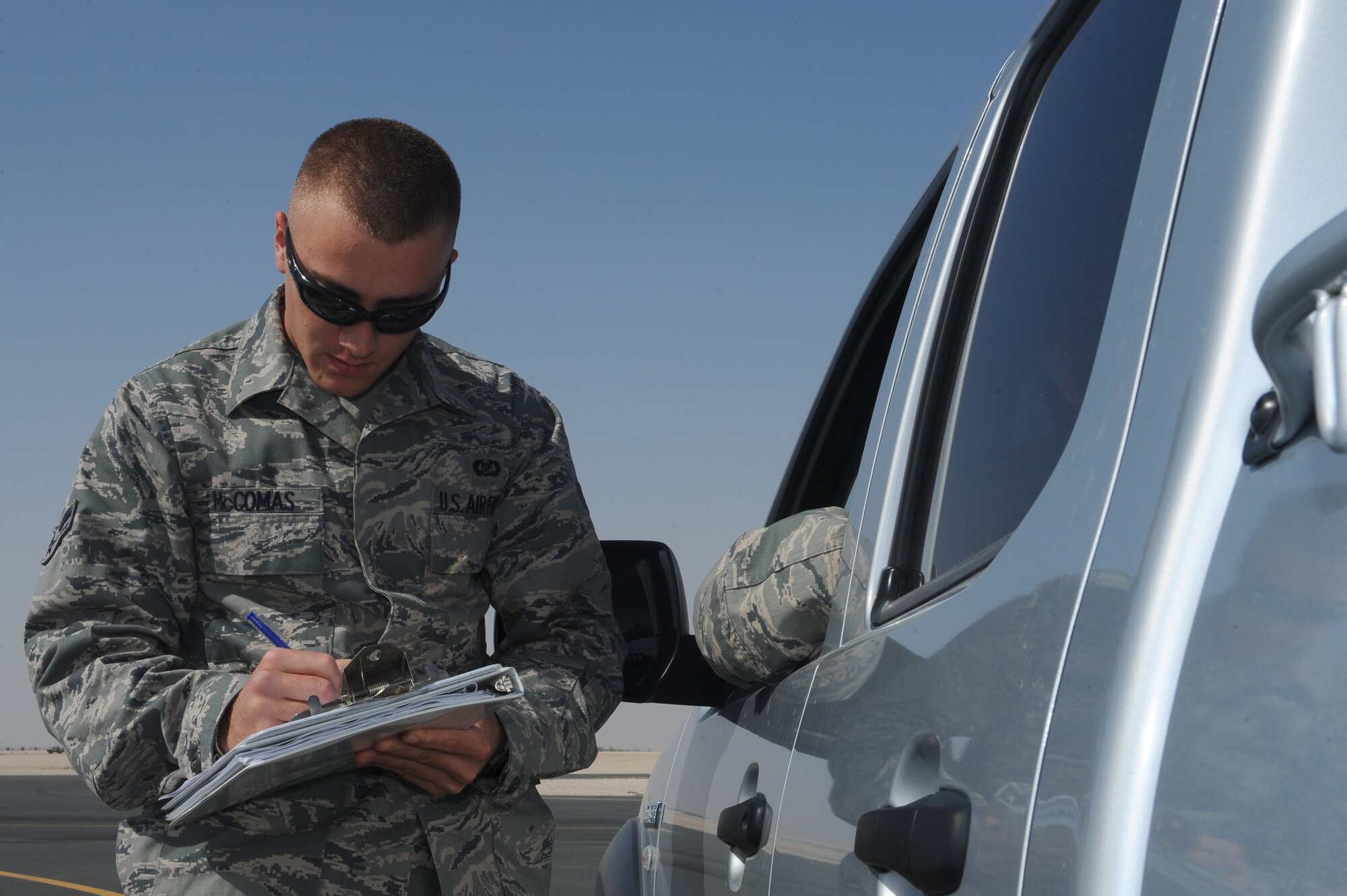 Airman 1st Class Christopher McComas, 379th Expeditionary Operations Support Squadron airfield operations coordinator, checks an Airman?s flightline driver license at a non-disclosed Southwest Asia location Feb. 3, 2010. (U.S. Air Force photo by Senior Airman Kasey Zickmund)[RELEASED]