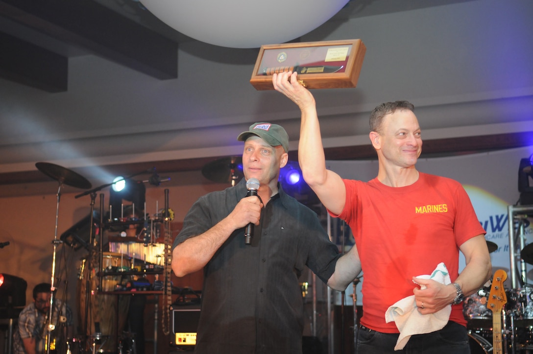 Col. Mark A. Werth, station commanding officer, presents Gary Sinise, actor and bass guitarist for the Lt. Dan Band, with a Ka-Bar and air station coin after the band’s performance at the Marine Corps Air Station in Yuma, Ariz., Feb. 13, 2010. The event was hosted by TriWest and sponsored by the USO. Nearly 350 service members and civilians turned up to watch the band. Playing for almost two-and-a-half hours, the band provided covers of songs from different musical eras, from “(You Make Me Feel Like) A Natural Woman” to psychedelic classic "Purple Haze."