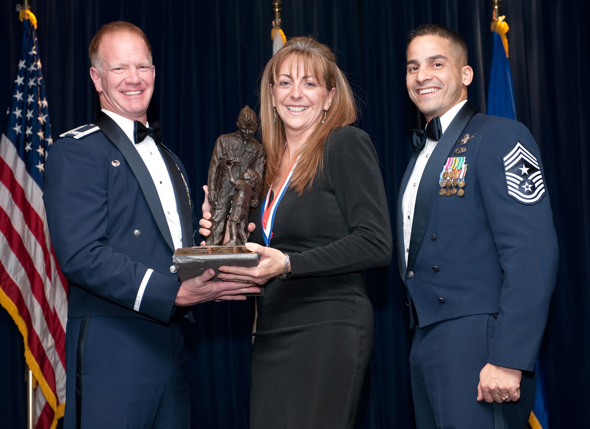 YOKOTA AIR BASE, Japan -- Col. J. Marcus Hicks, 374th Airlift Wing commander, and Chief Master Sgt. Benjamin Caro Jr., 374th AW command chief master sergeant, presents Ms. Janet Evans, center, with the US/JN Civilian Category II, Feb. 3. Ms. Eveans is assigned to the  374th Force Support Squadron. (U.S. Air Force photo/Osakabe Yasuo)