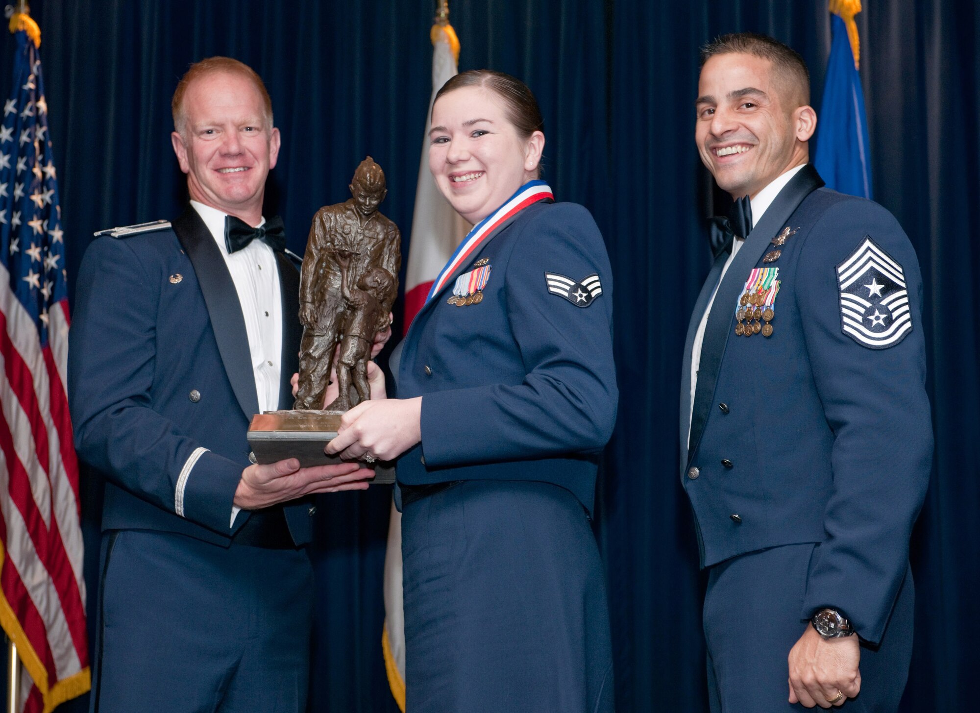 YOKOTA AIR BASE, Japan -- Col. J. Marcus Hicks, 374th Airlift Wing commander, and Chief Master Sgt. Benjamin Caro Jr., 374th AW command chief master sergeant, presents Senior Airman Lacey Garcia, center, with the Kensei Airman of the Year award, Feb. 3. Airman Garcia is assigned to the Department of Defense Special Representative Japan. (U.S. Air Force photo/Osakabe Yasuo)
