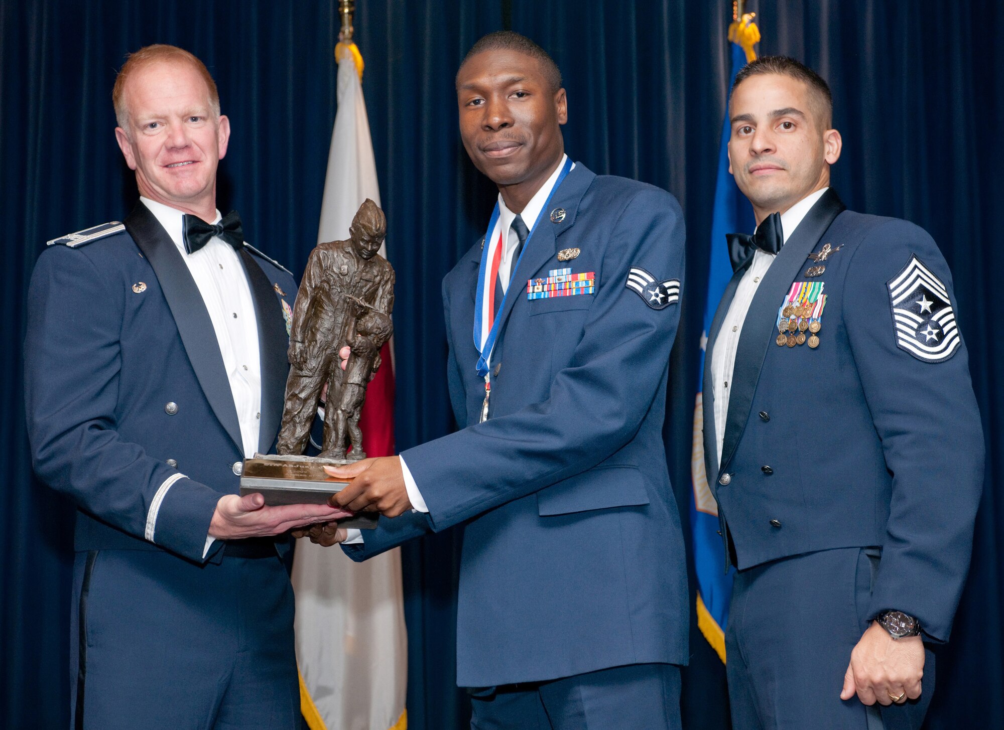 YOKOTA AIR BASE, Japan -- Col. J. Marcus Hicks, 374th Airlift Wing commander, and Chief Master Sgt. Benjamin Caro Jr., 374th AW command chief master sergeant, presents Senior Airman AnJuan Thomas with the Samurai Airman of the Year award Feb. 3. Airman Thomas is assigned to the 374th Mission Support Group. (U.S. Air Force photo/Osakabe Yasuo)