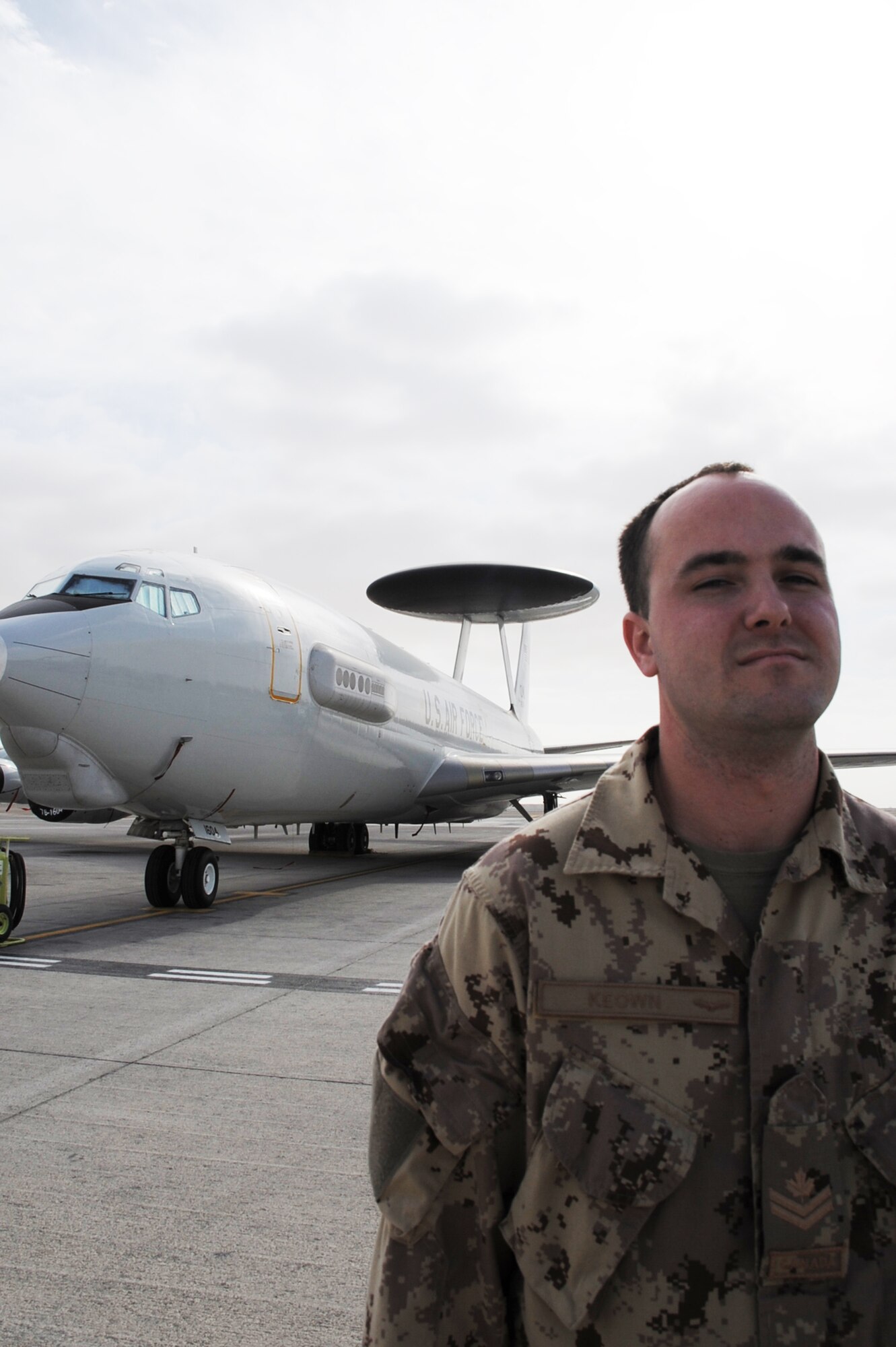 Canadian Forces Master Cpl. Mark Keown is an air surveillance technician serving with the 965th Expeditionary Airborne Air Control Squadron at a non-disclosed base in Southwest Asia. Here he is pictured next to an E-3 Sentry Airborne Warning and Control System aircraft on Jan. 28, 2010.  He is one of five Canadian Forces members deployed with the squadron.  Master Corporal Keown's hometown is Powassan, Ontario, Canada.  (U.S. Air Force Photo/Master Sgt. Scott T. Sturkol/Released)