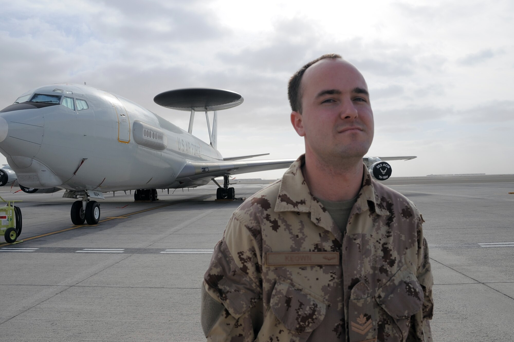 Canadian Forces Master Cpl. Mark Keown is an air surveillance technician serving with the 965th Expeditionary Airborne Air Control Squadron at a non-disclosed base in Southwest Asia. Here he is pictured next to an E-3 Sentry Airborne Warning and Control System aircraft on Jan. 28, 2010.  He is one of five Canadian Forces members deployed with the squadron.  Master Corporal Keown's hometown is Powassan, Ontario, Canada.  (U.S. Air Force Photo/Master Sgt. Scott T. Sturkol/Released)