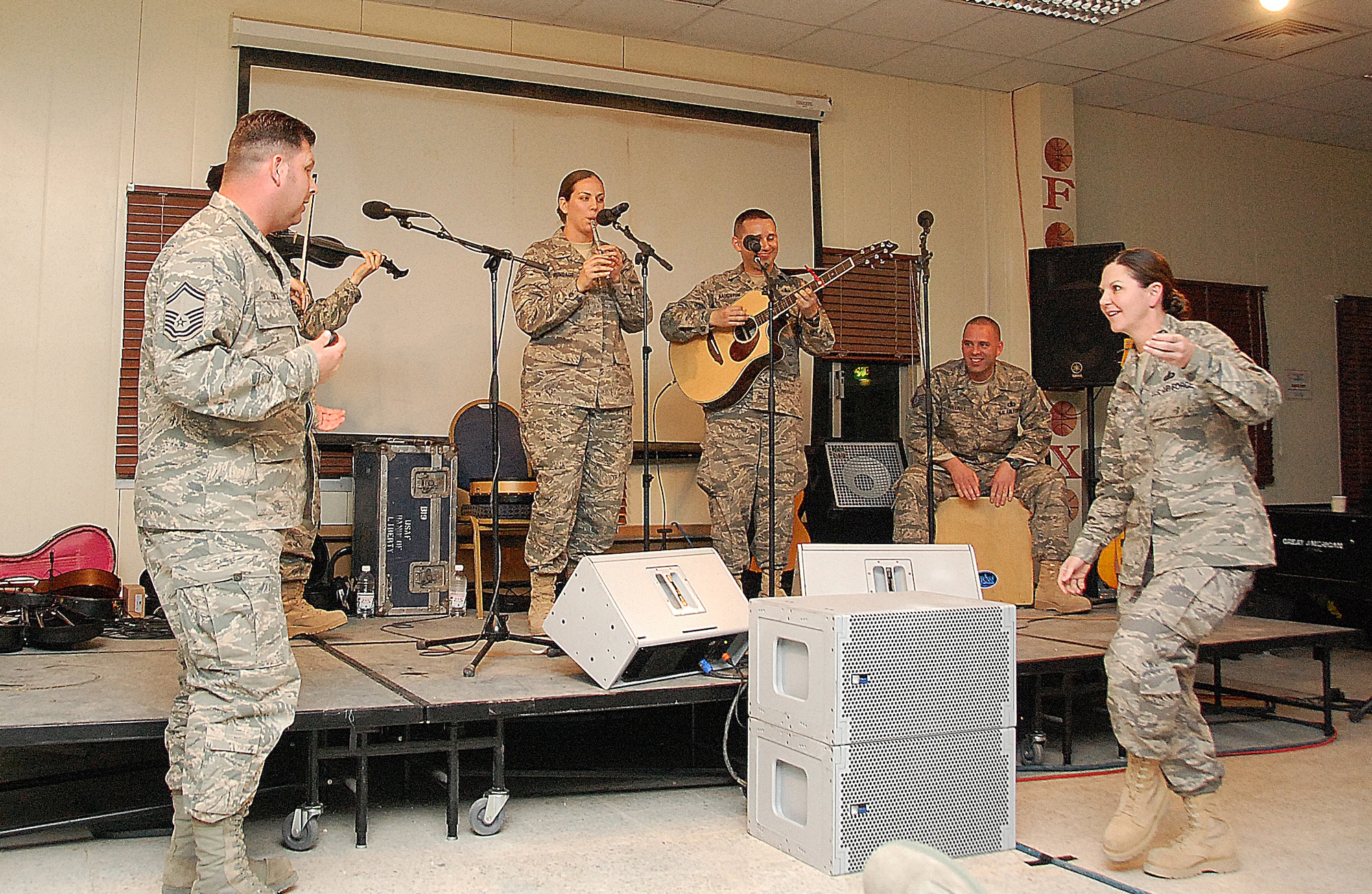 SOUTHWEST ASIA -- U.S. Air Force Senior Master Sgt. William Finch, left, 386th Expeditionary Civil Engineer Squadron, and Senior Master Sgt. Tammy Cope, right, 386th Expeditionary Force Support Squadron, join the U.S. Air Forces Central Command Celtic Aire band as they entertain members of the 386th Air Expeditionary Wing Feb. 13, 2010 at an air base in Southwest Asia. The undisclosed location is just one of many stops on the band's two-month tour through the AFCENT area of responsibility. (U.S. Air Force photo by Staff Sgt. Lakisha A. Croley/Released)