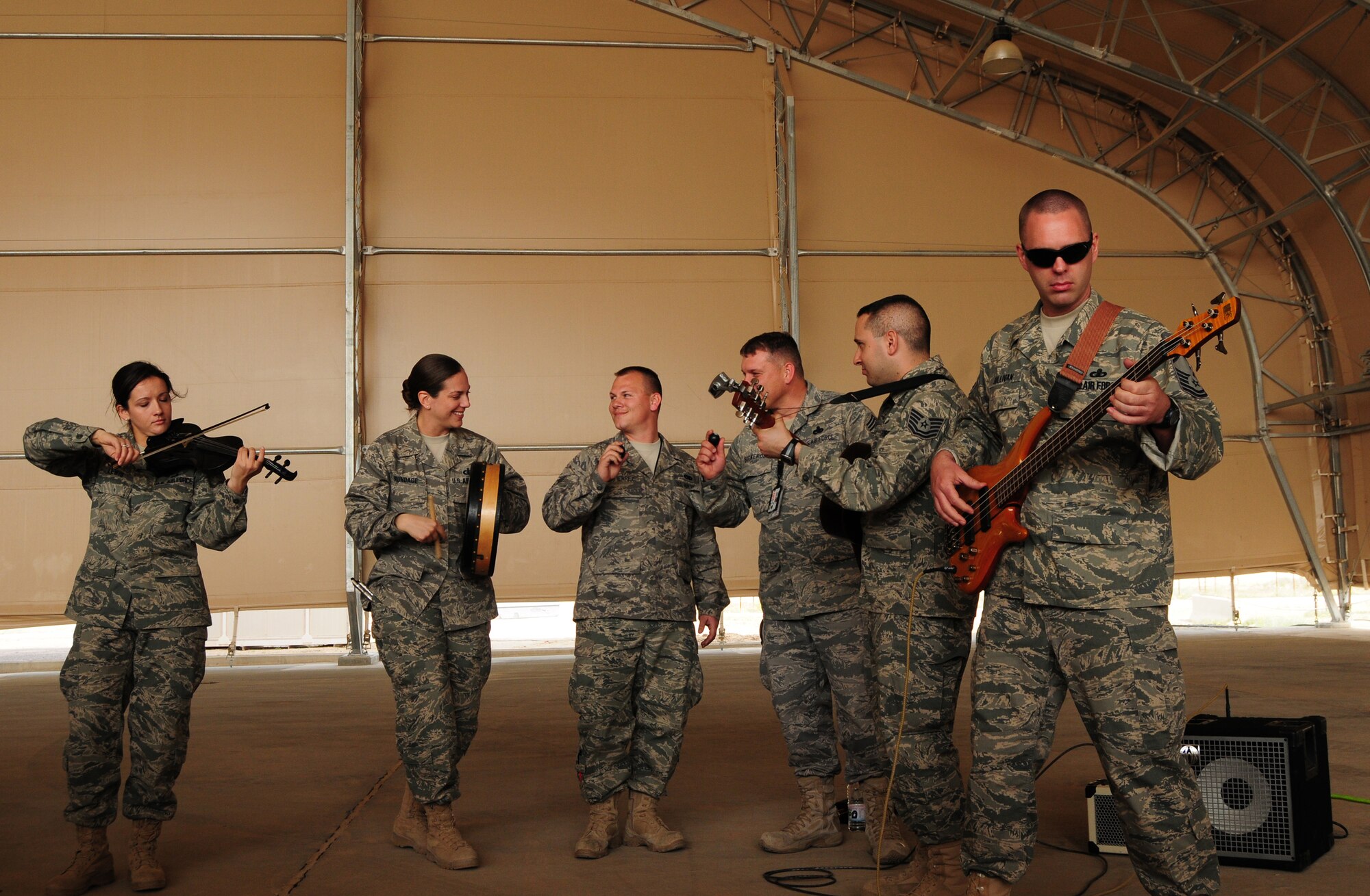 SOUTHWEST ASIA --  Center from left to right: Senior Amn Paul Gutierrez, 386th Expeditionary Aircraft Maintenance Squadron, and Chief Master Sgt. Anthony Bickerdike, 386th Expeditionary Aircraft Maintenance Squadron, join the U.S. Air Forces Central Command Celtic Aire band as they perform for members of the 386th EAMXS Feb. 13, 2010 at an air base in Southwest Asia. The undisclosed location is just one of many stops on the band's two-month tour through the AFCENT area of responsibility. (U.S. Air Force photo by Staff Sgt. Lakisha A. Croley/Released)