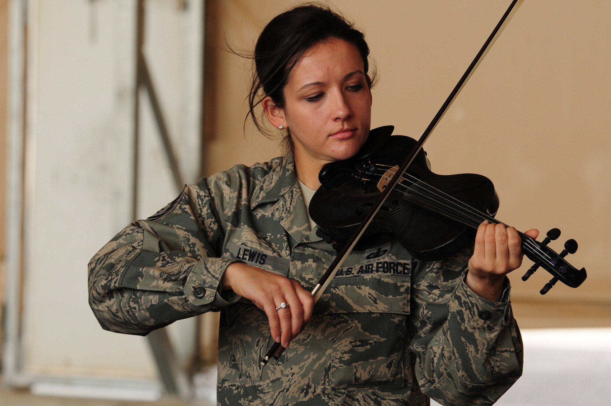 SOUTHWEST ASIA -- U.S. Air Force Tech. Sgt. Emily Lewis, violinist and vocalist for the U.S. Air Forces Central Command Celtic Aire band, entertains members of the 386th Expeditionary Aircraft Maintenance Squadron Feb. 13, 2010 at an air base in Southwest Asia. The undisclosed location is just one of many stops on the band's two-month tour through the AFCENT area of responsibility. (U.S. Air Force photo by Staff Sgt. Lakisha A. Croley/Released)