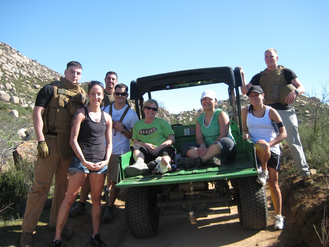 Lance Cpls. Justis Beauregard (far left), a combat correspondent with Marine Wing Headquarters Squadron 3, 3rd Marine Aircraft Wing, and Josh Rucker (far right), a reproduction specialist with Headquarters and Headquarters Squadron, Marine Corps Air Station Miramar, pose with Christine Anderson (center) who injured her ankle while hiking on Mount Woodson in Poway, Calif., Feb. 15. The Marines helped splint Anderson's broken ankle with skills they learned in a Marine Corps combat lifesaver course and created and expedient stretcher with their flak jackets to carry her to waiting emergency personnel.::r::::n::