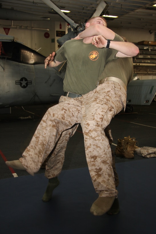 Sgt. William Anderson, police sergeant, 24th Marine Expeditionary Unit, launches Sgt. Matthew Butler, motor transport chief, 24th MEU, into the air with a counter to the rear hand choke during their Marine Corps Martial Arts Program Course in the hangar bay aboard USS Nassau Feb. 15. MCMAP entails many types of hand to hand combat training and ground fighting. Marines and Sailors are currently going through a refresher course and will soon work to advance their skills. (U.S. Marine Corps photo by Lance Cpl. David J. Beall)