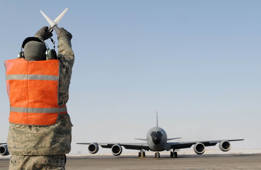 U.S. Air Force Senior Airman James Partin, 376th Expeditionary Aircraft Maintenance Squadron instrument and flight control systems technician, marshals a KC-135 Stratotanker to the taxiway before take-off from the Transit Center at Manas, Kyrgyzstan, Feb. 16, 2010. In a typical flight, a KC-135 refuels several aircraft, and in the course of a deployment they'll off-load millions of pounds of fuel to hundreds of aircraft, supporting thousands of troops on the ground. (U.S. Air Force photo/Senior Airman Nichelle Anderson/released)