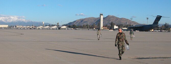 A small group of Airmen patrol a section of the aircraft parking ramp, filling plastic bags with debris that could cause foreign object damage to March’s C-17s or KC-135s. The 200 walkers retrieved 24 pounds of debris during the walk. The next walk is scheduled for Apr. 7. (U.S. Air Force photo by Megan Just)