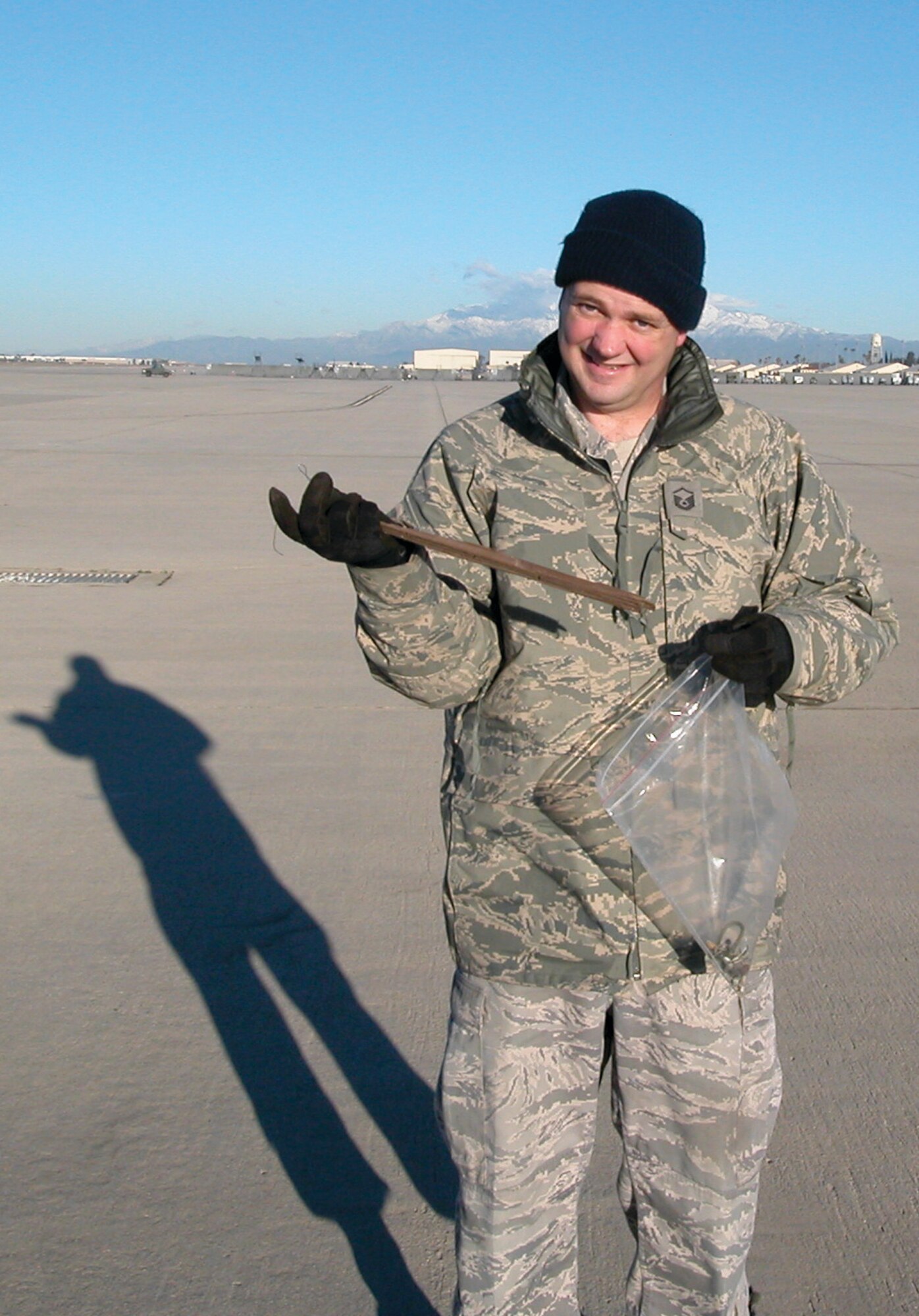 Master Sgt. Thomas Hackmann holds a long wood splinter he found on the ramp, Jan. 28. Pieces of wood are often carried onto the ramp area by fast moving water.   (U.S. Air Force photo by Megan Just)