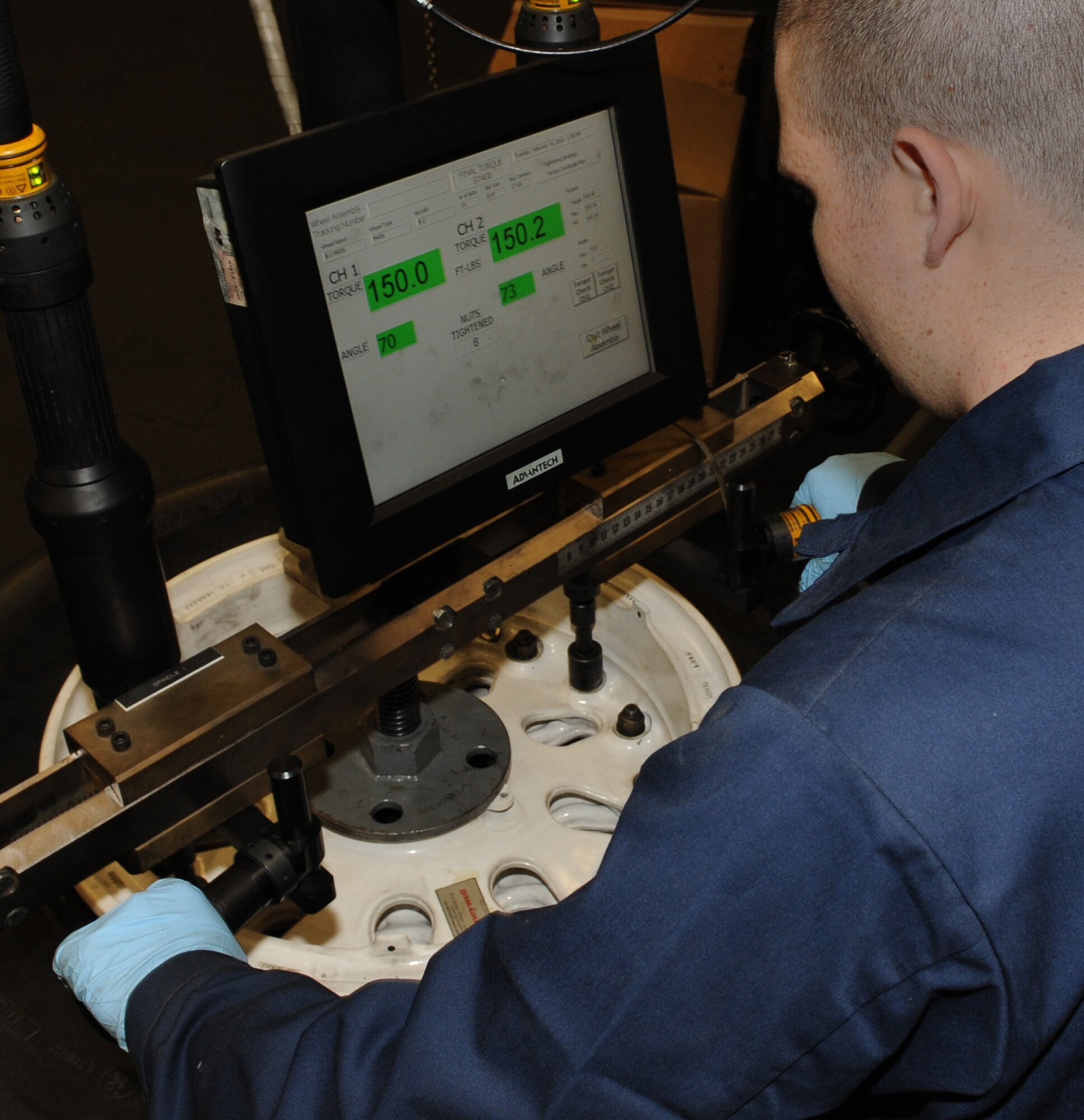 WHITEMAN AIR FORCE BASE, Mo. - Staff Sgt. Travis Hughes, 509th Aircraft Maintenance Squadron wheel and tire shop NCO in charge, guides a specialized wheel assembly torquing system to bolt a B-2 wheel and tire together, Feb. 16, 2010. The machine ensures proper torque is applied to each nut, ensuring the two-piece wheel is sealed air-tight . (U.S. Air Force photo/Airman 1st Class Carlin Leslie)