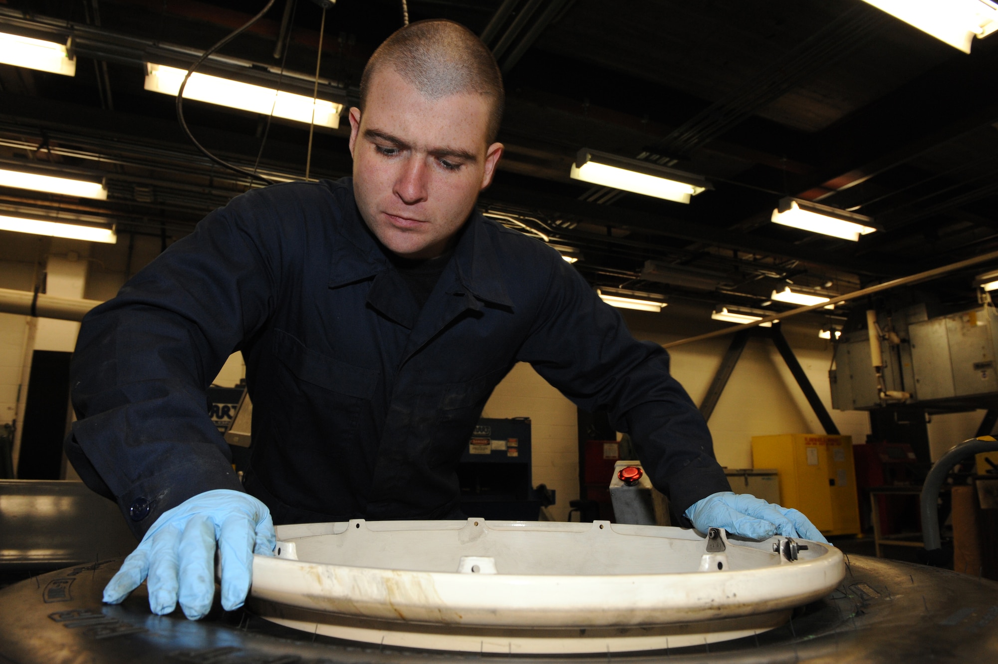 WHITEMAN AIR FORCE BASE, Mo. - Staff Sgt. Travis Hughes, 509th Aircraft Maintenance Squadron wheel and tire shop NCO in charge, places two wheel halves together in a B-2 tire, Feb. 16, 2010.  Each B-2 wheel weighs in excess of 275 lbs., and requires the use of specialized, automated equipment for assembly. (U.S. Air Force photo/Airman 1st Class Carlin Leslie)