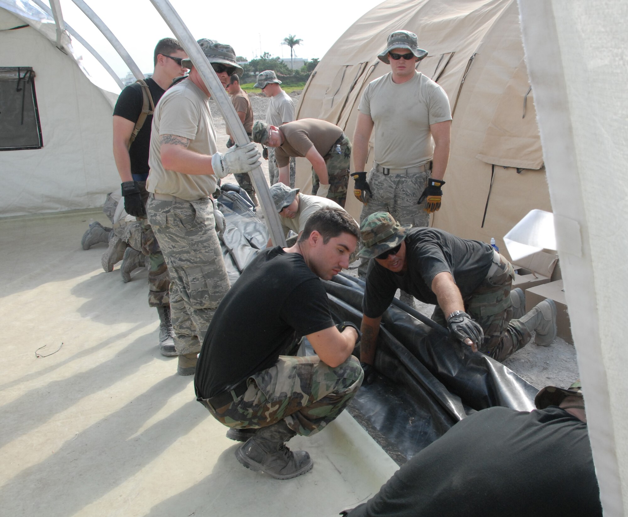 Staff Sgt. Travis Barclay, pointing, directs other Airman while building a tent to be used for medical and relief operations.