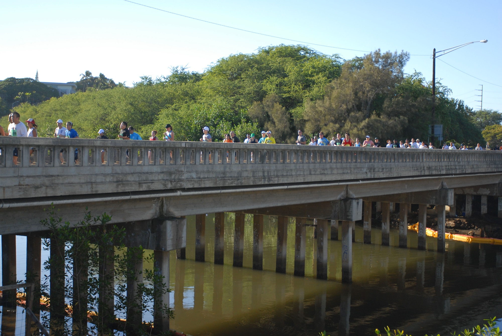Participants cross a bridge next to Aloha Stadium during the Great Aloha Run Feb. 15. The run spanned over 8.15 miles which began at Aloha Tower, finished at Aloha Stadium, and boasted more than 17,000 participants. (U.S. Air Force photo by Senior Airman Gustavo Gonzalez)