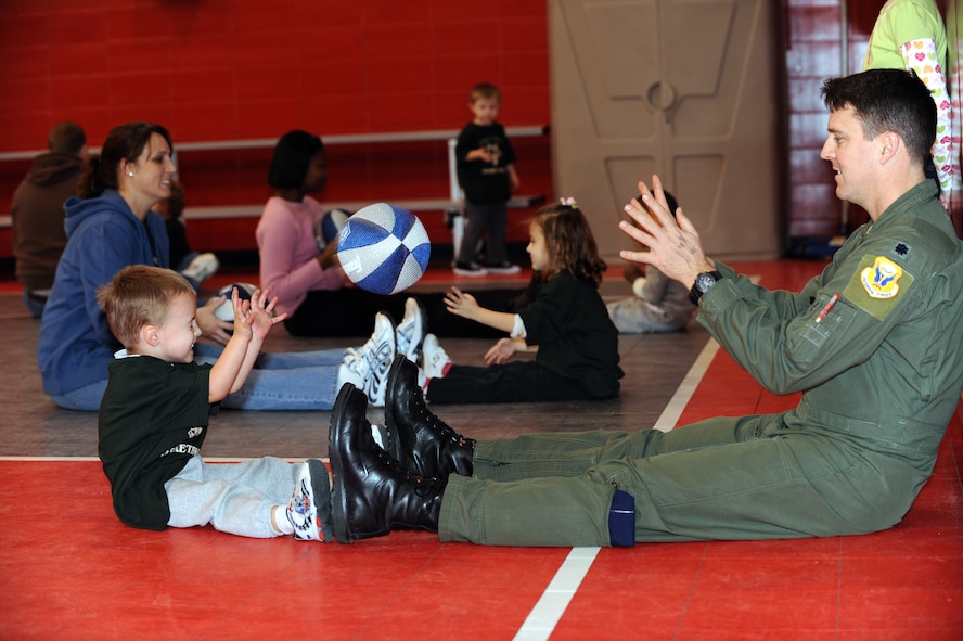 WHITEMAN AIR FORCE BASE, Mo. - Lt. Col. Jason Armagost, 13th Bomb Squadron commander, passes a soft basketball to his son Reece Armagost, during the Start Smart sports development activity Feb. 12, 2010.Whiteman Youth Center provides the Start Smart program to parents of children ages 3-to 5-years-old. The program provides parents the opportunity to bond with their children while teaching the children basic sports fundamentals. (U.S. Air Force photo/Tech. Sgt. Charles Larkin Sr)
