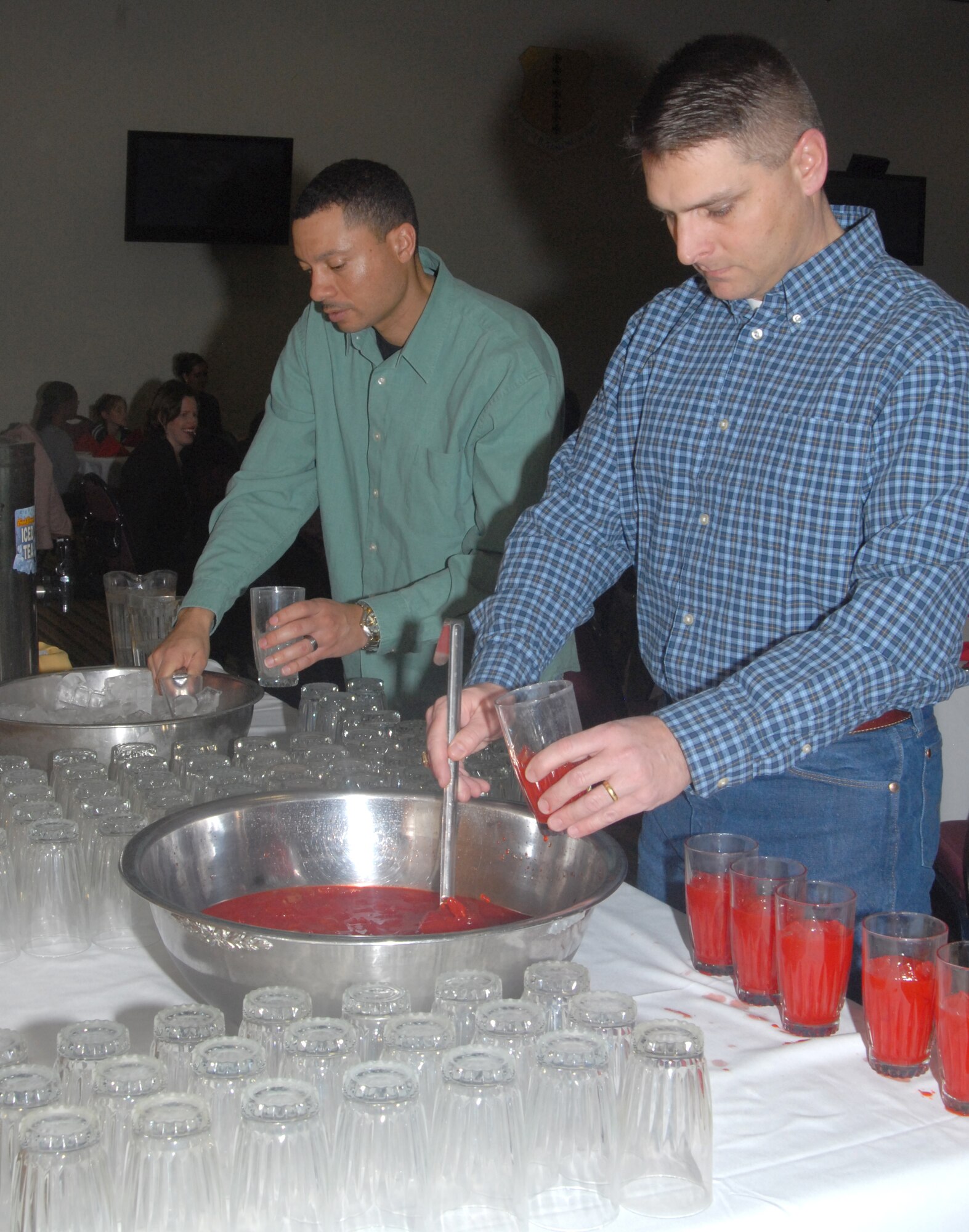 Master Sgt. John Guidry, 316th Training Squadron first sergeant and Lt. Col. Erick Lawson, 316 TRS commander, serve drinks during the Key Spouses dinner, Thursday night at the Event Center. ( U.S. Air Force photo by Airman 1st Class Anne Gathua)

