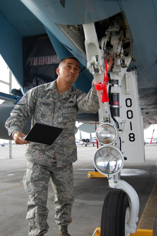 NELLIS AIR FORCE BASE, Nev. -- Tech. Sgt. Raymond Oliveros, a dedicated crew chief integrated into the Regular Air Force's 757th Aircraft Maintenance Squadron here, assesses nose landing gear on an F-15 Aggressor aircraft during a through-flight inspection. (U.S. Air Force Reserve photo/Capt. Jessica Martin)