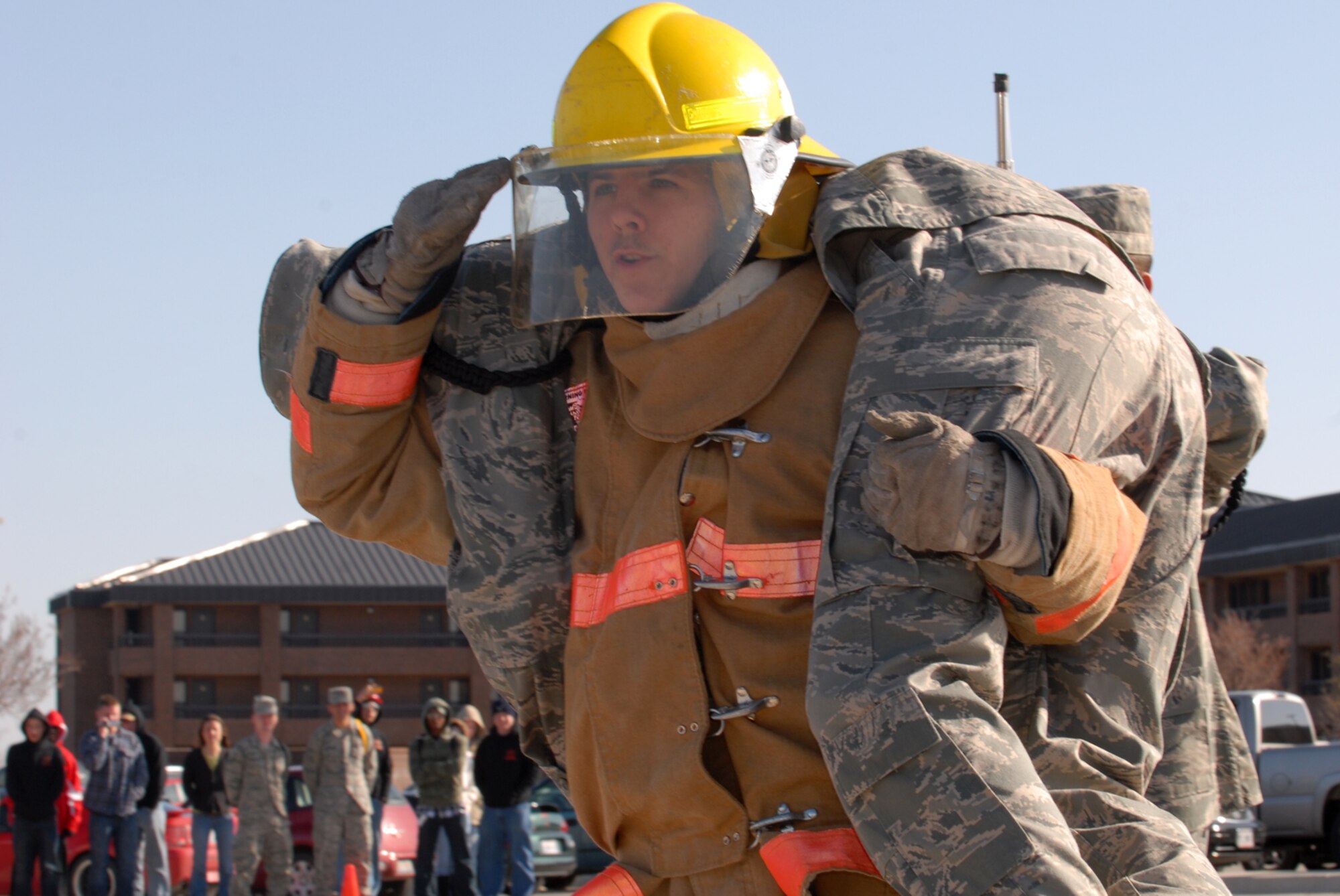 GOODFELLOW AIR FORCE BASE, Texas -- Airman Basic Brandon Berard, a student from the 312th Training Squadron, salutes while conducting the fireman's carry during the 1st quarter drill team competition, Feb. 13, 2010. Airman Berard is a member of the 312th TRS black ropes drill team. (U.S. Air Force photo/Staff Sgt. Laura R. McFarlane)

