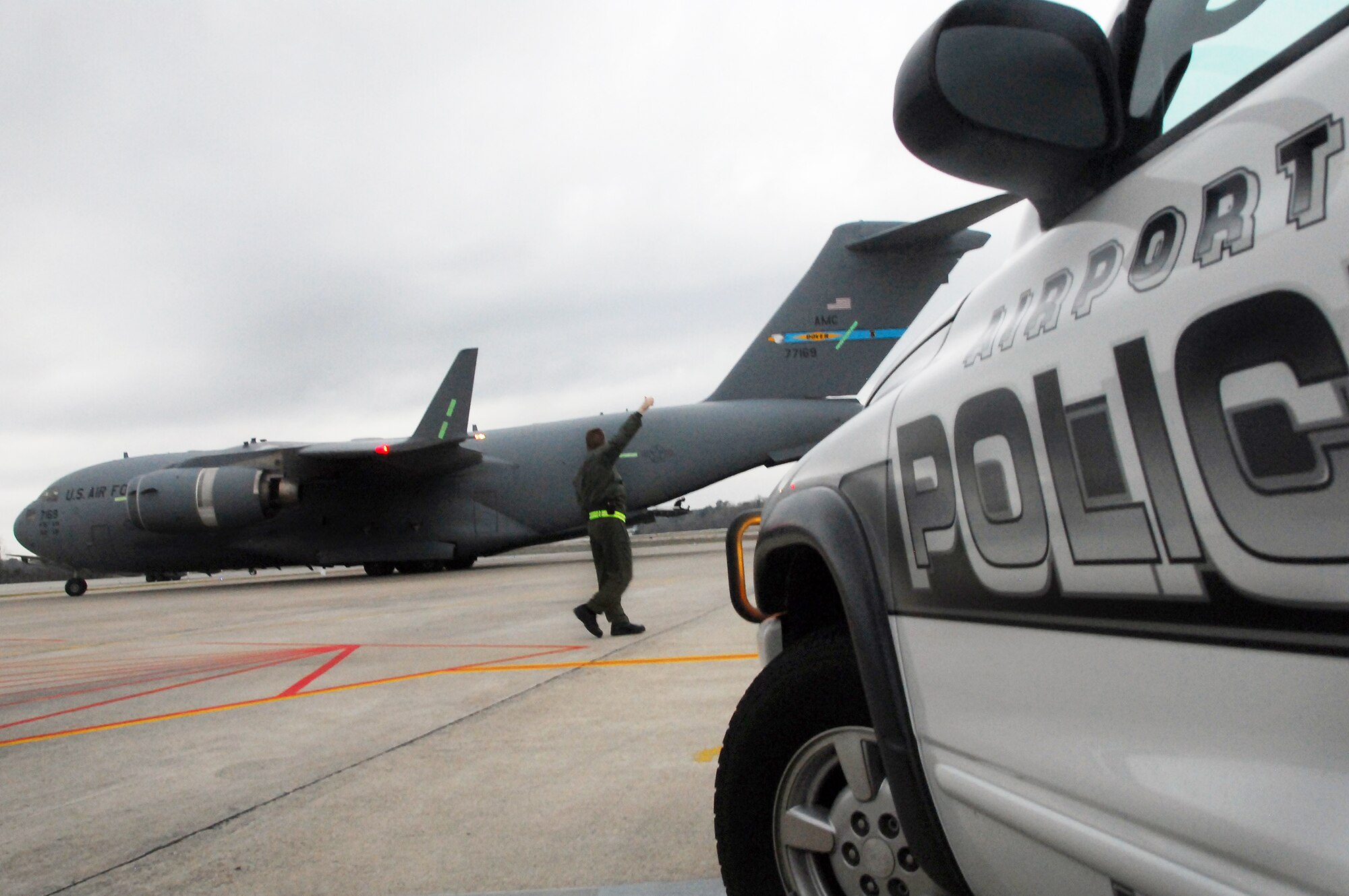 Lt. Col. John Donahue signals "all clear" to the aircrew of a taxiing C-17 Globemaster III after transporting evacuees Feb. 9, 2010, from Haiti to Charleston International Airport in South Carolina. Evacuee flights began arriving in Charleston Feb. 4, and Colonel Donahue is currently leading a team of officers acting as liaison between Air Force mission planners and local civilian authorities in charge of repatriation efforts. Colonel Donahue is the 628th Air Base Wing chief of Wing Plans. (U.S. Air Force photo/Staff Sgt. Daniel Bowles)