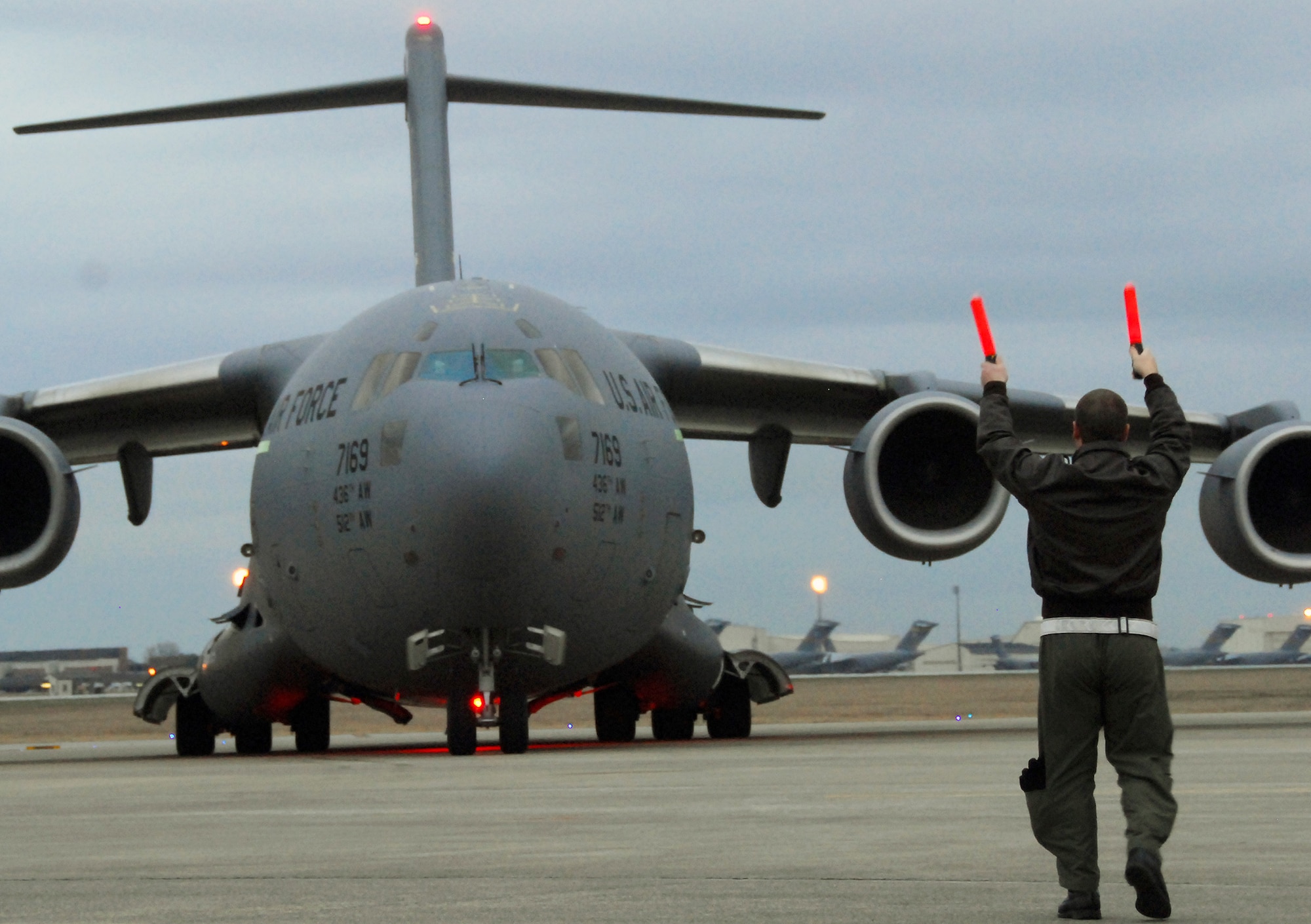 Capt. Tony Mione marshals a C-17 Globemaster III transporting evacuees Feb. 9, 2010, from Haiti to Charleston International Airport in South Carolina. Aircraft on evacuations missions arriving at the airport are limited to 75 passengers per mission. As of Feb. 9, more than 700 evacuees had transited the airport. Captain Mione is the deputy chief of Wing Plans for the 437th Airlift Wing. (U.S. Air Force photo/Staff Sgt. Daniel Bowles)