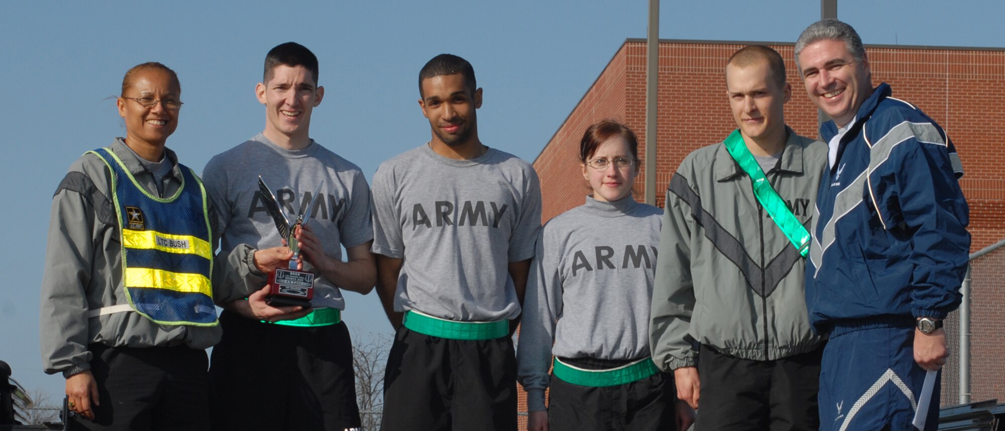 GOODFELLOW AIR FORCE BASE, Texas -- Army Lt. Col. Bichson Bush (left), 344th Military Intelligence Battalion commander, and Soldiers from Alpha Company accept the quarterly sports day trophy from Col. Thomas Geary, 17th Training Wing commander, Feb. 12, 2010. Sports day provided a variety of activities for all participants including volleyball, tennis, dodge ball and more. (U.S. Air Force photo/Staff Sgt. Laura R. McFarlane)
