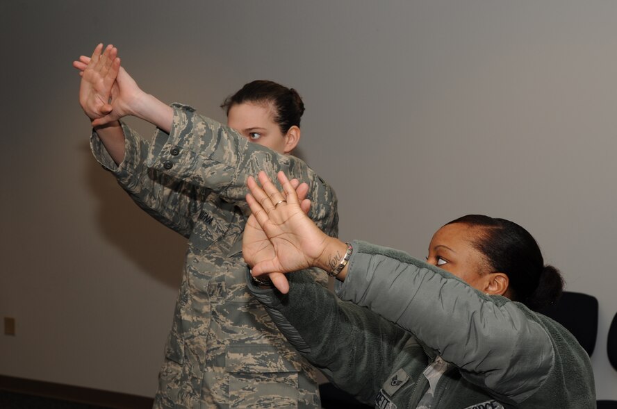 Staff Sgt. Mia Hackett, 4th Security Forces Squadron combat arms instructor, demonstrates a dominant eye test for Senior Airman Trisha Arena, 916th Air Refueling Wing aircrew flight equipment reservist, before M-9 weapon qualification on Seymour Johnson Air Force Base, N.C., Feb. 12, 2010. The test identifies the dominate eye which looks directly at an object and the non-dominant eye, which looks at the same object but at a slight angle. Hackett hails from Seattle and Arena is from Chicago. (U.S. Air Force photo/ Staff Sgt. Courtney Richardson)