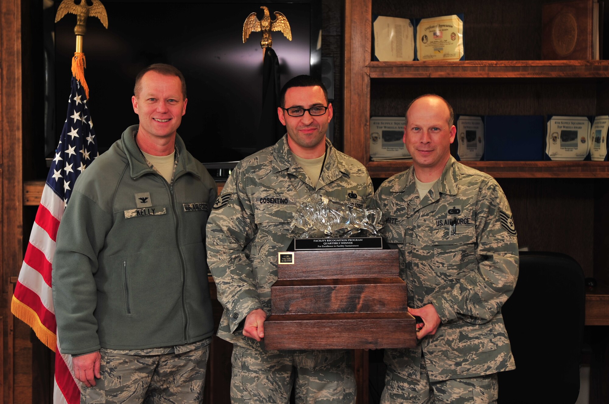 Col. Mark Kelly, 4th Fighter Wing commander, presents Staff Sgt. Daniel Cosentino and Tech. Sgt. Timothy Whitt, both 4th Logistics Readiness Squadron fuel technicians, with the Facility Recognition Program Quarterly award for excellence in facility sustainment. The 4th LRS Fuels Lab earned this recognition for the first quarter because of the overall effort they put into  improving their workplace making it stand out above their competition. (U.S. Air Force photo/Senior Airman Rae Perry)  