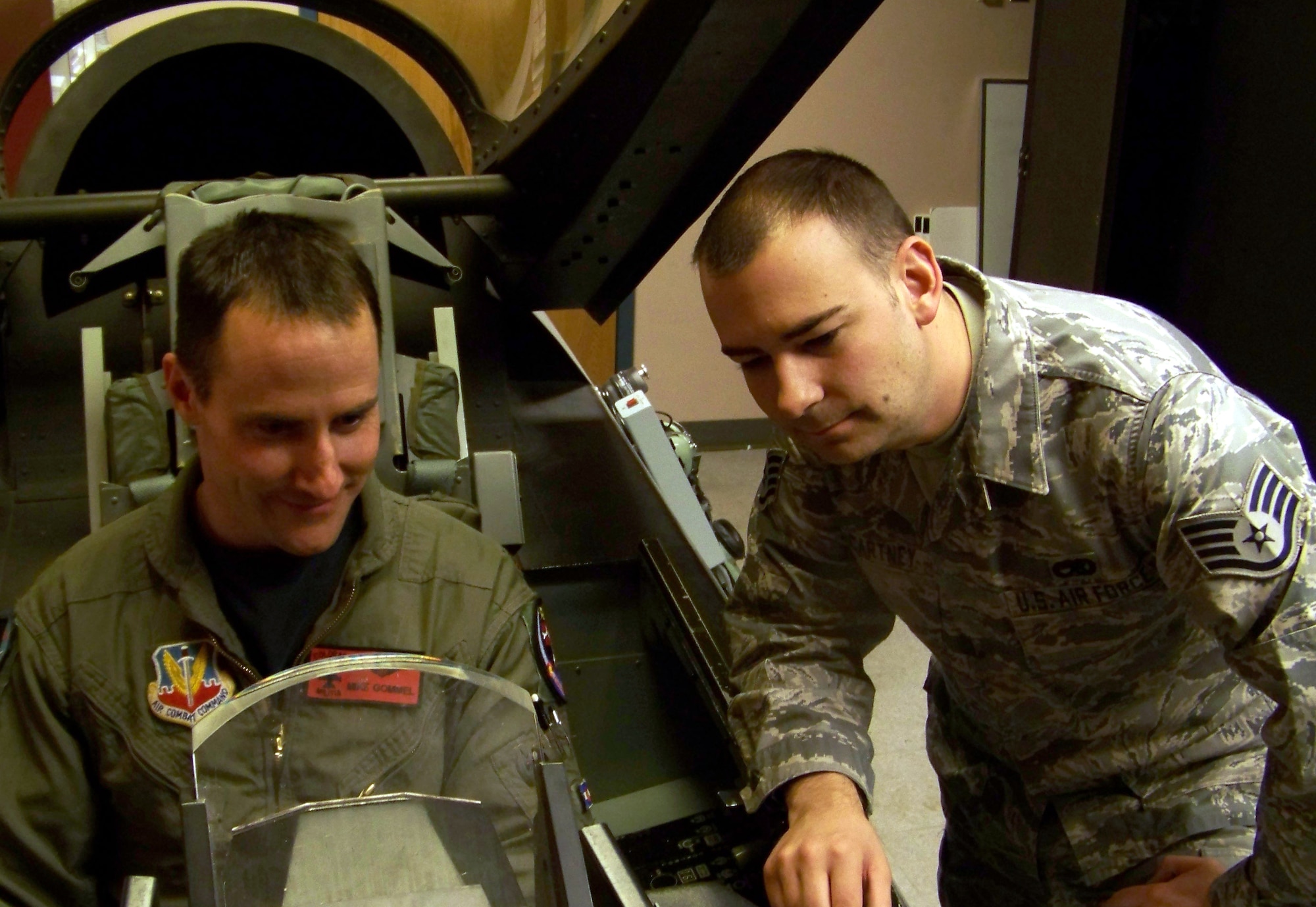 Staff Sgt. Jared McCartney, 120th Fighter Squadron, helps Maj. Michael Gommel egress an F-16 Fighting Falcon simulator. Sergeant McCartney is Team Buckley's Warrior of the Week for Feb. 15. (U.S. Air Force photo)