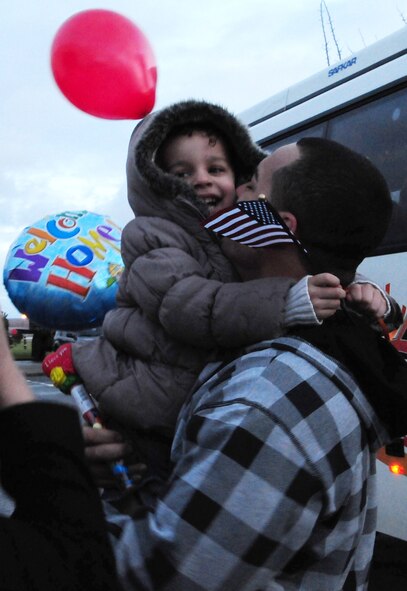 Staff Sgt. John Garcia, 100th Security Forces Squadron, gives his daughter, Jessenia, 4, kisses and a huge hug when he returned from a deployment Feb. 13. A total of 28 100th SFS troops returned home after being gone for eight months -- two months training in Nevada, followed by a six-month deployment in Iraq. (U.S. Air Force photo by Karen Abeyasekere)