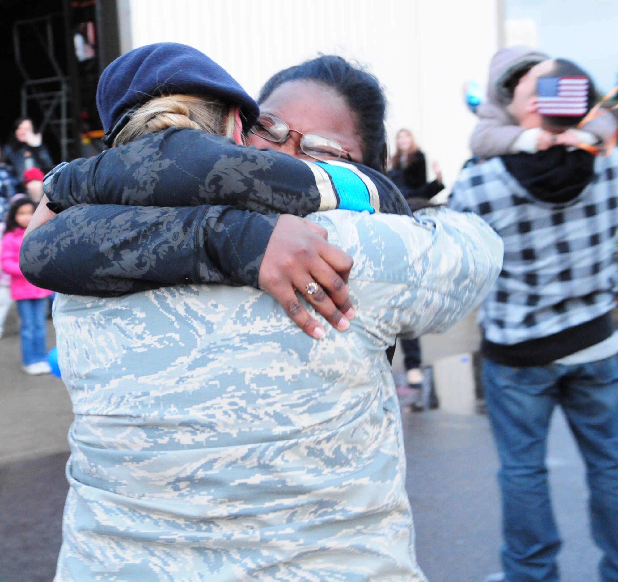 Airman 1st Class Melissa Campbell (in uniform) hugs her friend Airman 1st Class Tuwanda Worthy, in an emotional greeting when Airman Worthy returned to RAF Mildenhall Feb. 13 after a six-month deployment to Iraq. The two Airmen came to RAF Mildenhall together from tech. school. (U.S. Air Force photo by Karen Abeyasekere)