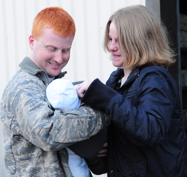 Senior Airman William Sprayberry, left, 100th Security Forces Squadron, gazes adoringly at his new baby son, Connor, born Jan. 6, as his fiancee, Airman 1st Class Chelsea Burke, also 100th SFS, looks proudly at them both. This was the very first time Airman Sprayberry saw his newborn son. "I'm kind of speechless right now, just taking it all in," he said. (U.S. Air Force photo by Karen Abeyasekere)
