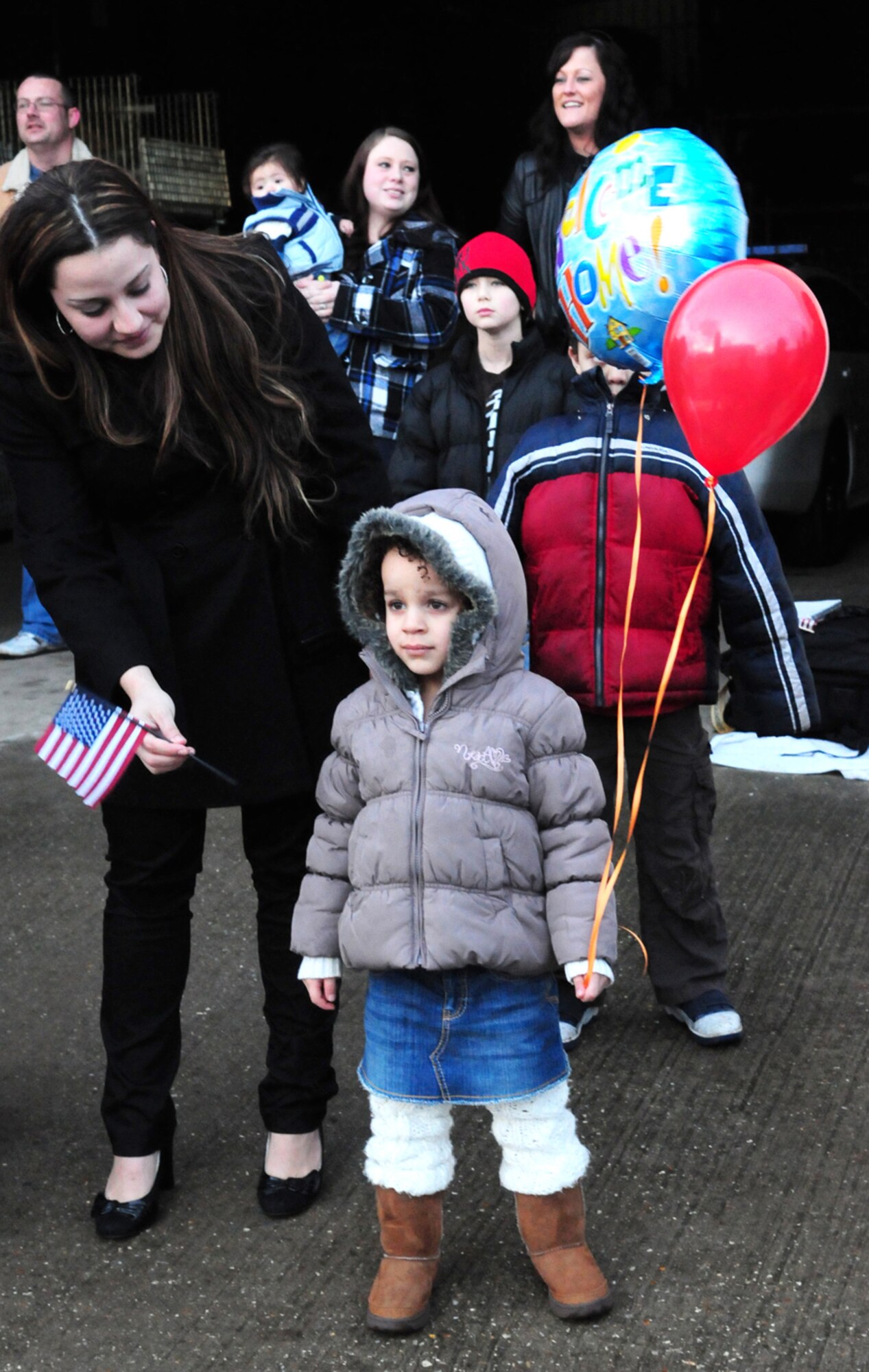 Jessenia Garcia, 4, waits anxiously with her balloons as she prepares to see her daddy again after eight months. Her dad, Staff Sgt. John Garcia, 100th Security Forces Squadron, was one of 28 Airmen who returned home Feb. 13 after two months training and a six-month deployment in Iraq. (U.S. Air Force photo by Karen Abeyasekere)