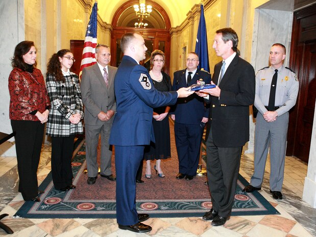 Senior Master Sergeant Dean Johnson, First Sergeant with the 560th Red Horse Squadron at Charleston AFB, S.C., presents an American flag to South Carolina Governor Mark Sanford.  Sergeant Johnson, a reservist and state employee, presented the flag to the governor for the outstanding support he received from his civilian employer during a recent deployment to Baghdad, Iraq.  (Courtesy Photo)