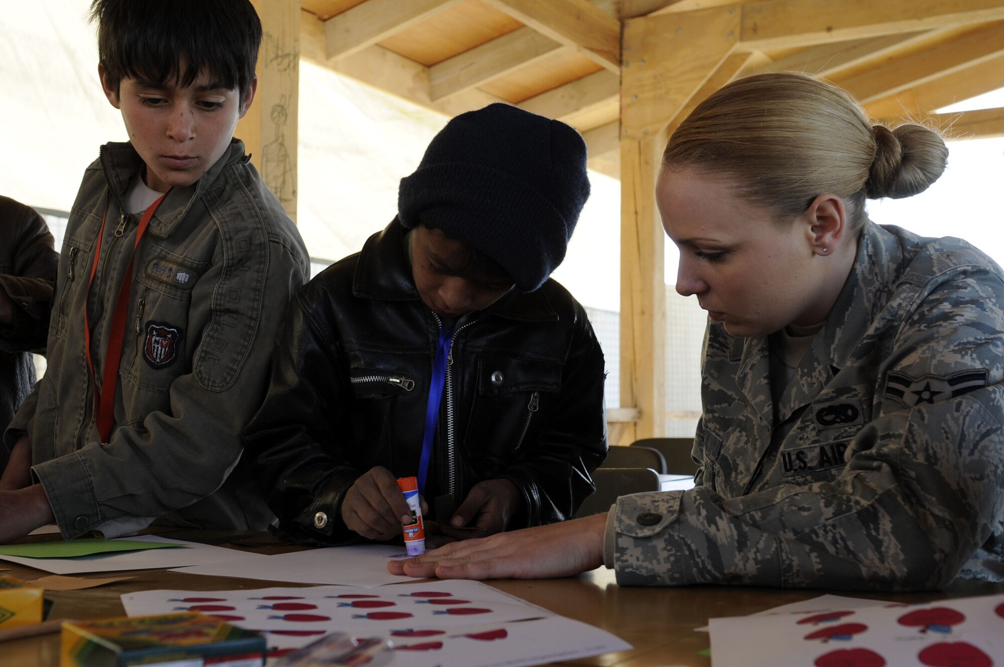 A members from the 451st Air Expeditionary Wing help make family trees with local Afghan children at the Bazaar School Feb. 15, 2010.  The Bazaar School is a place where local Afghan children can play games and participate in activities with military members from Kandahar Airfield.  (U.S. Air Force photo/Senior Airman Nancy Hooks/Released)