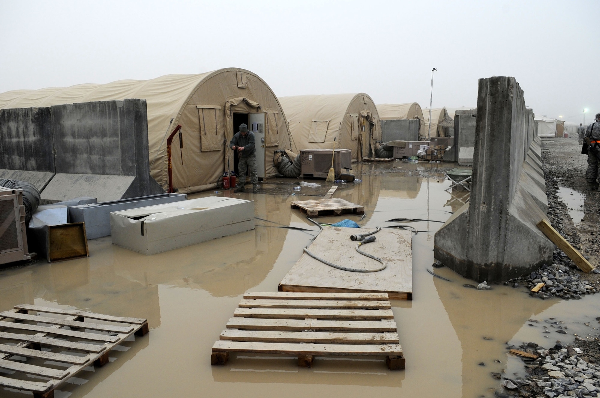 Airmen worked together to clean up after a flash flood that occurred on Kandahar Airfield Feb. 8.  Airment in South Park awoke in the middle of the night to flood waters reaching approximately knee-deep in height both inside and outside their tents.  (U.S. Air Force photo/Senior Airman Nancy Hooks)