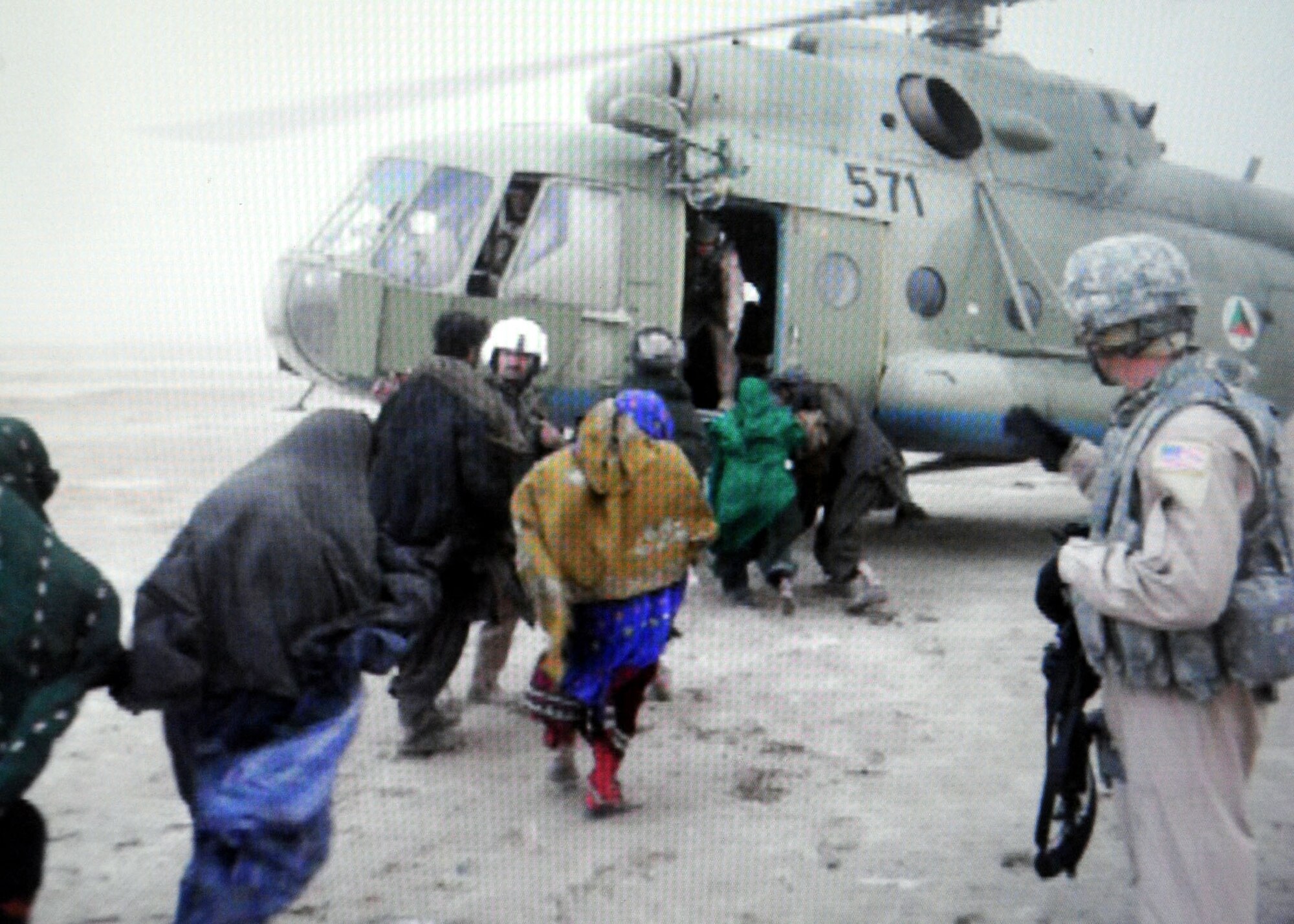 A snapshot of a video shows U.S. Air Force and Afghan National Army Air Corps servicemembers conducting a humanitarian rescue mission of members of the Kuchi tribe after a flash flood nearly overtook their village located 30 kilometers southwest of Kandahar Airfield Feb. 8.  (U.S. Air Force imagery by Lt. Col. Christopher Prejean/Released)